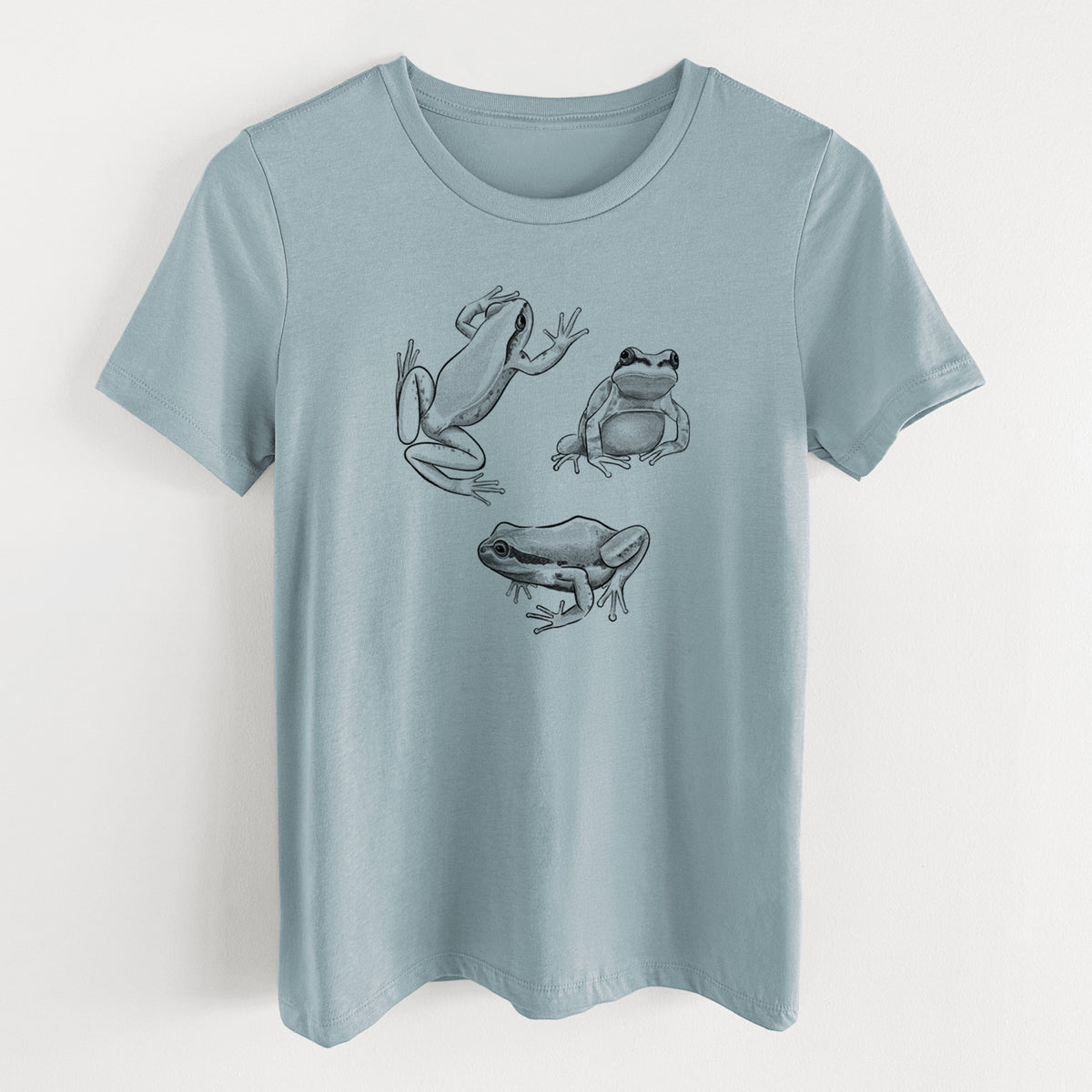 Vintage denim women's relaxed fit cotton t-shirt laid flat, printed with a black ink illustration of three Pacific tree frogs in different poses.