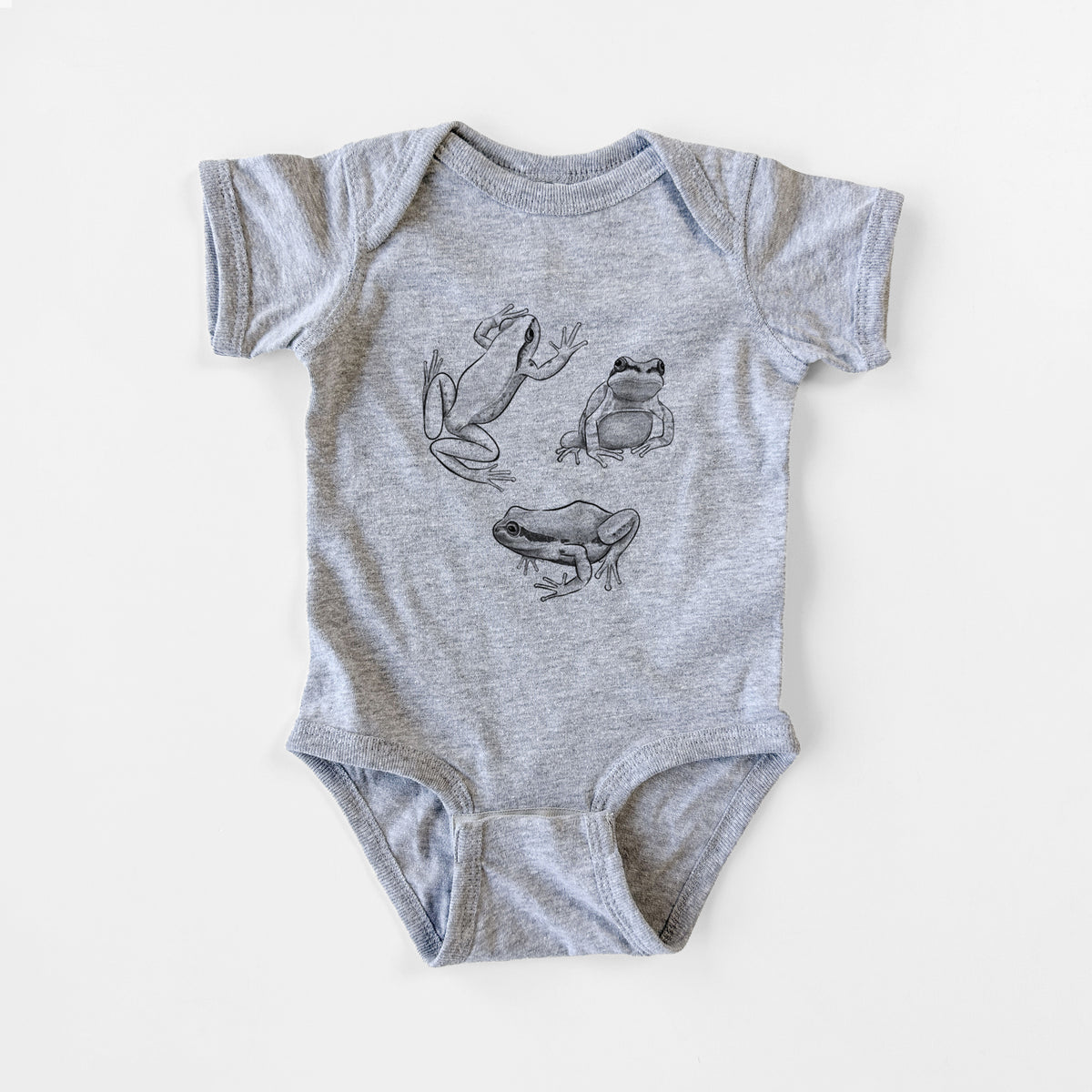 Grey baby bodysuit laid flat, printed with a black ink illustration of three Pacific tree frogs in different poses.