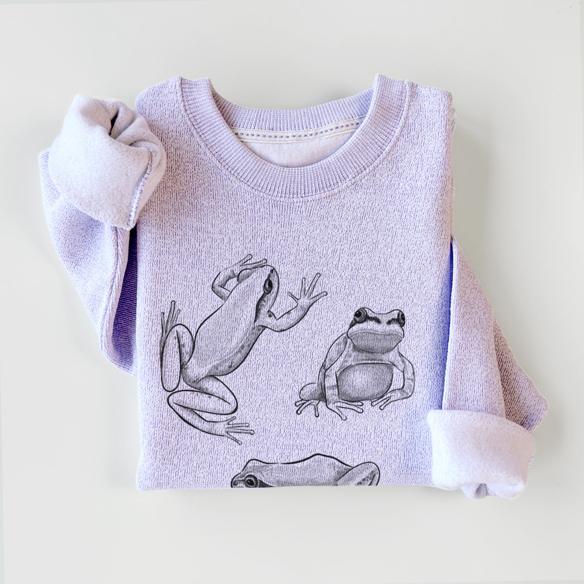 Ice purple knit sweatshirt printed with a black ink illustration of three Pacific tree frogs in different poses, styled flat.