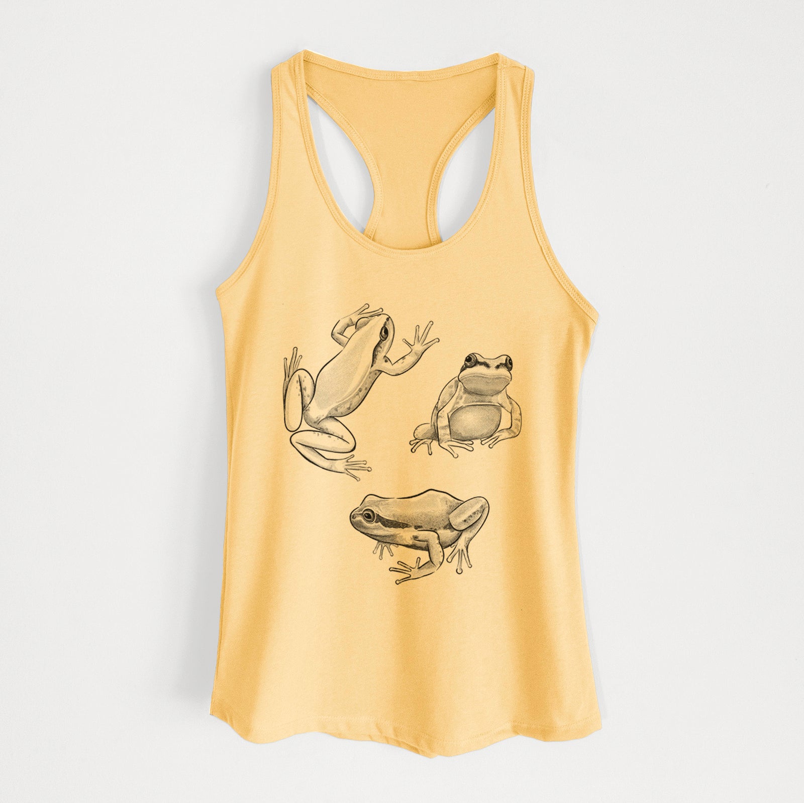 Banana cream women's racerback tank top laid flat, printed with a black ink illustration of three Pacific tree frogs in different poses.