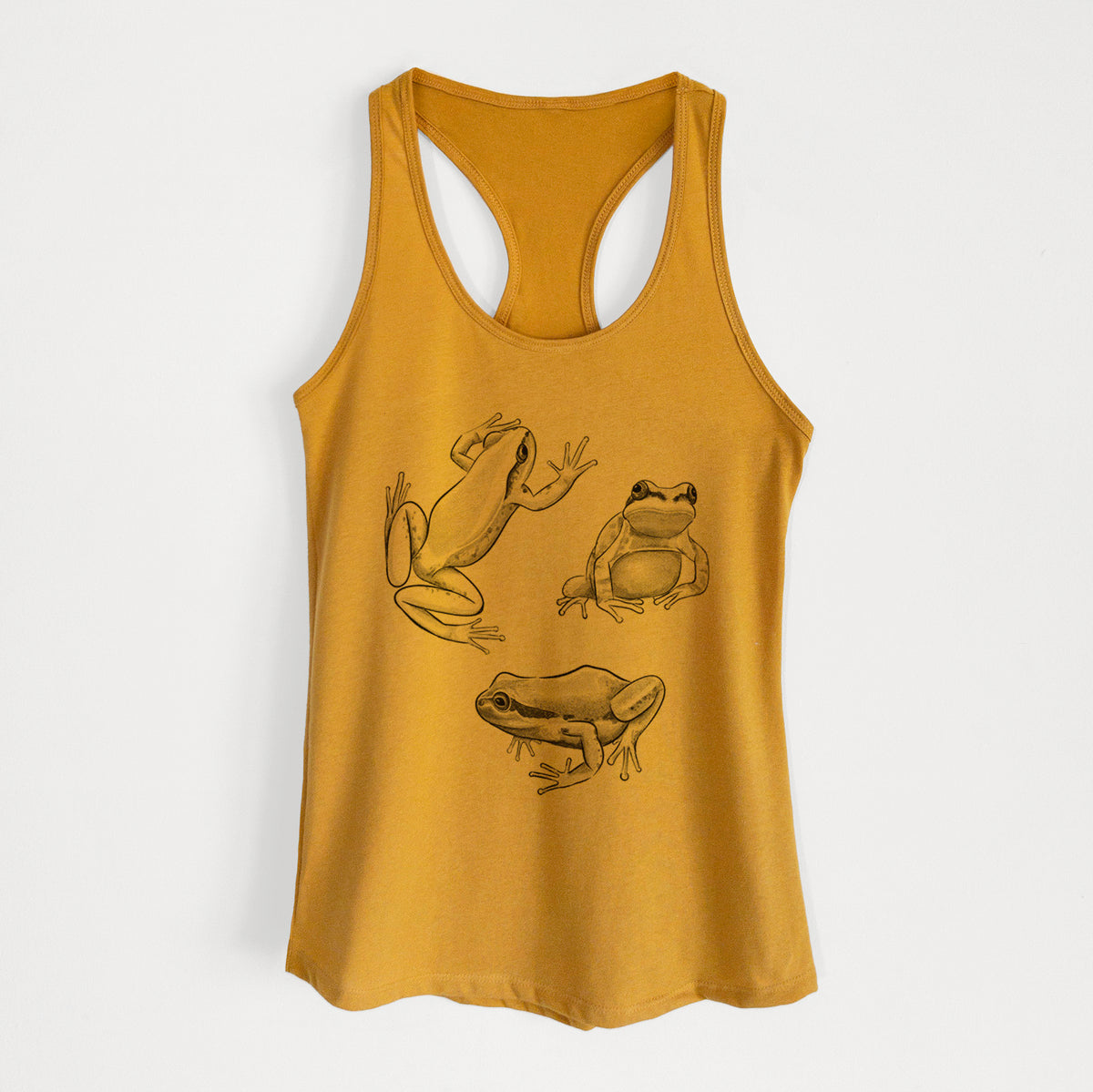 Gold women's racerback tank top laid flat, printed with a black ink illustration of three Pacific tree frogs in different poses.