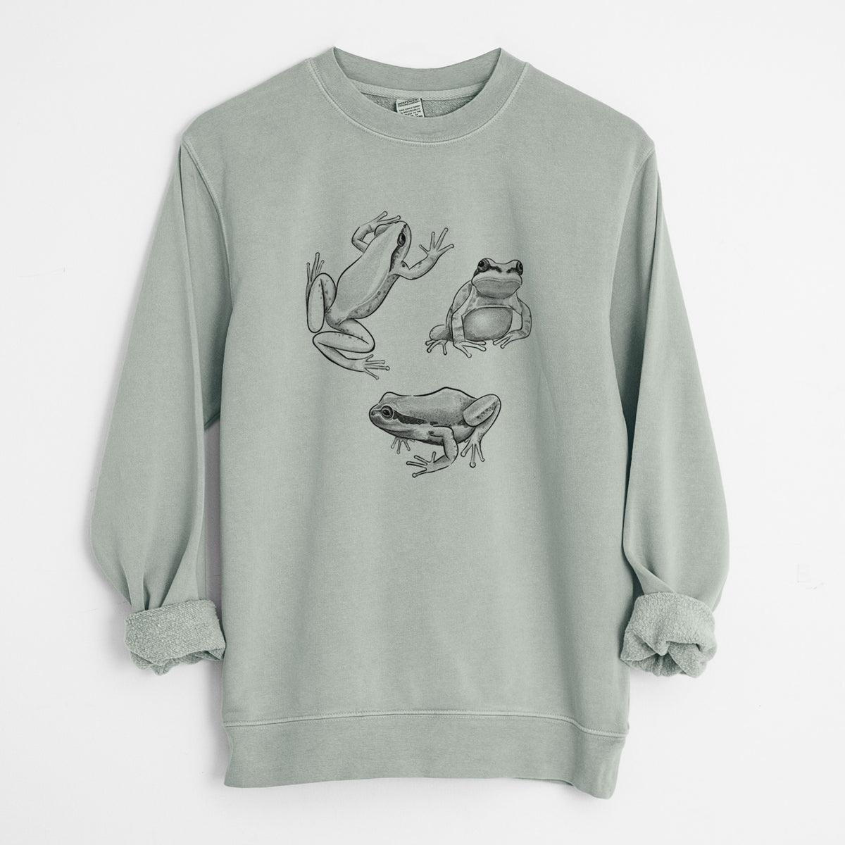 Sage green pigment dyed crewneck sweatshirt laid flat with the sleeves rolled, printed with a black ink illustration of three Pacific tree frogs in different poses.