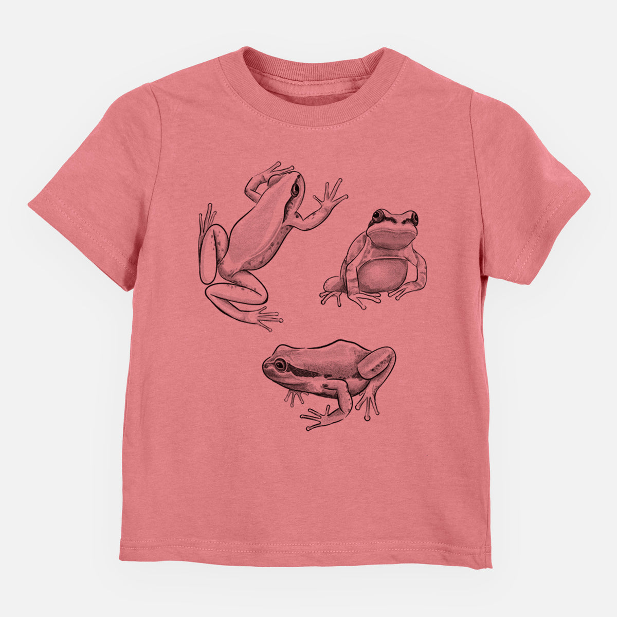 Mauve pink toddler t-shirt laid flat, printed with a black ink illustration of three Pacific tree frogs in different poses.