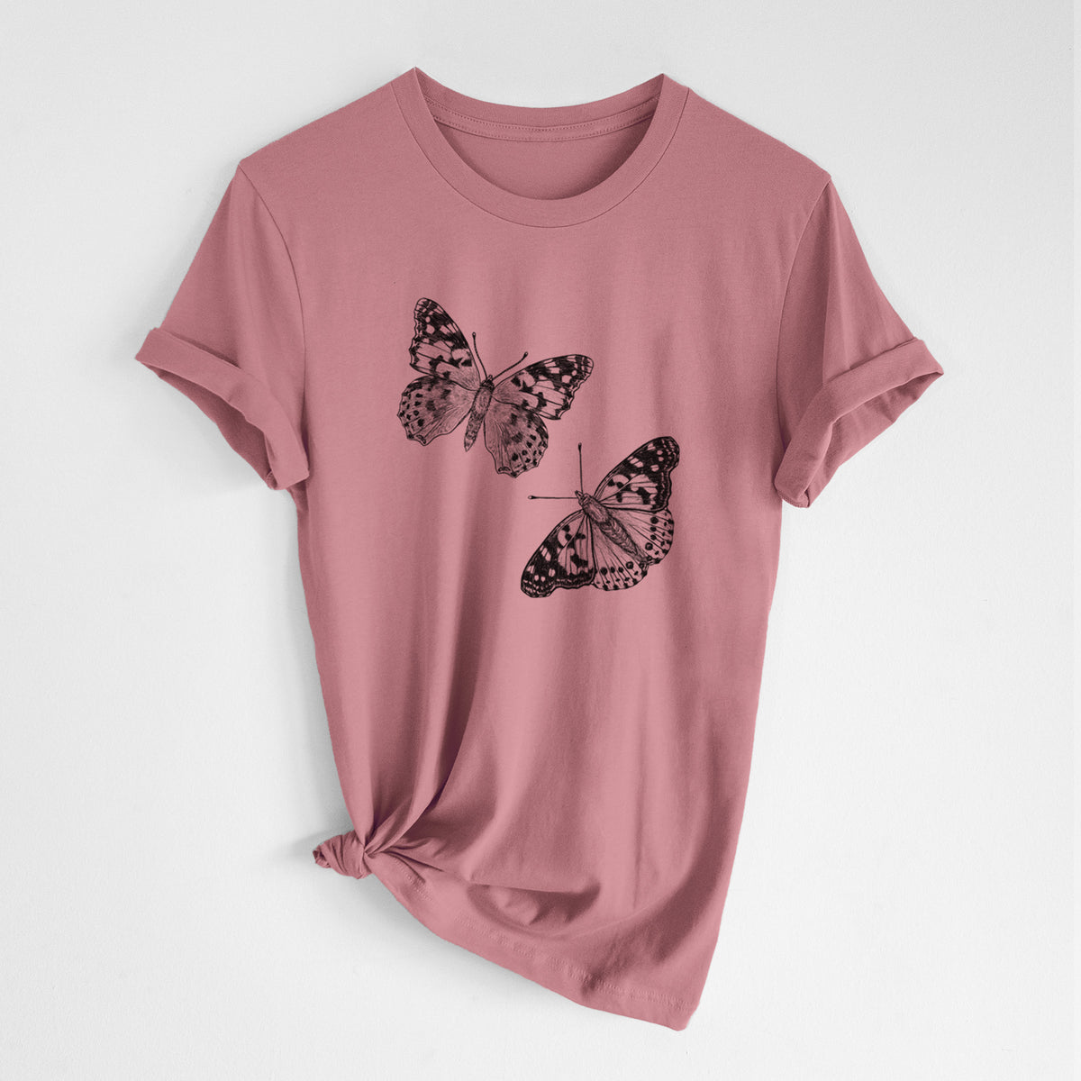 Mauve pink lightweight cotton t-shirt laid flat with the sleeves rolled, printed with a detailed black ink illustration of two painted lady butterflies.