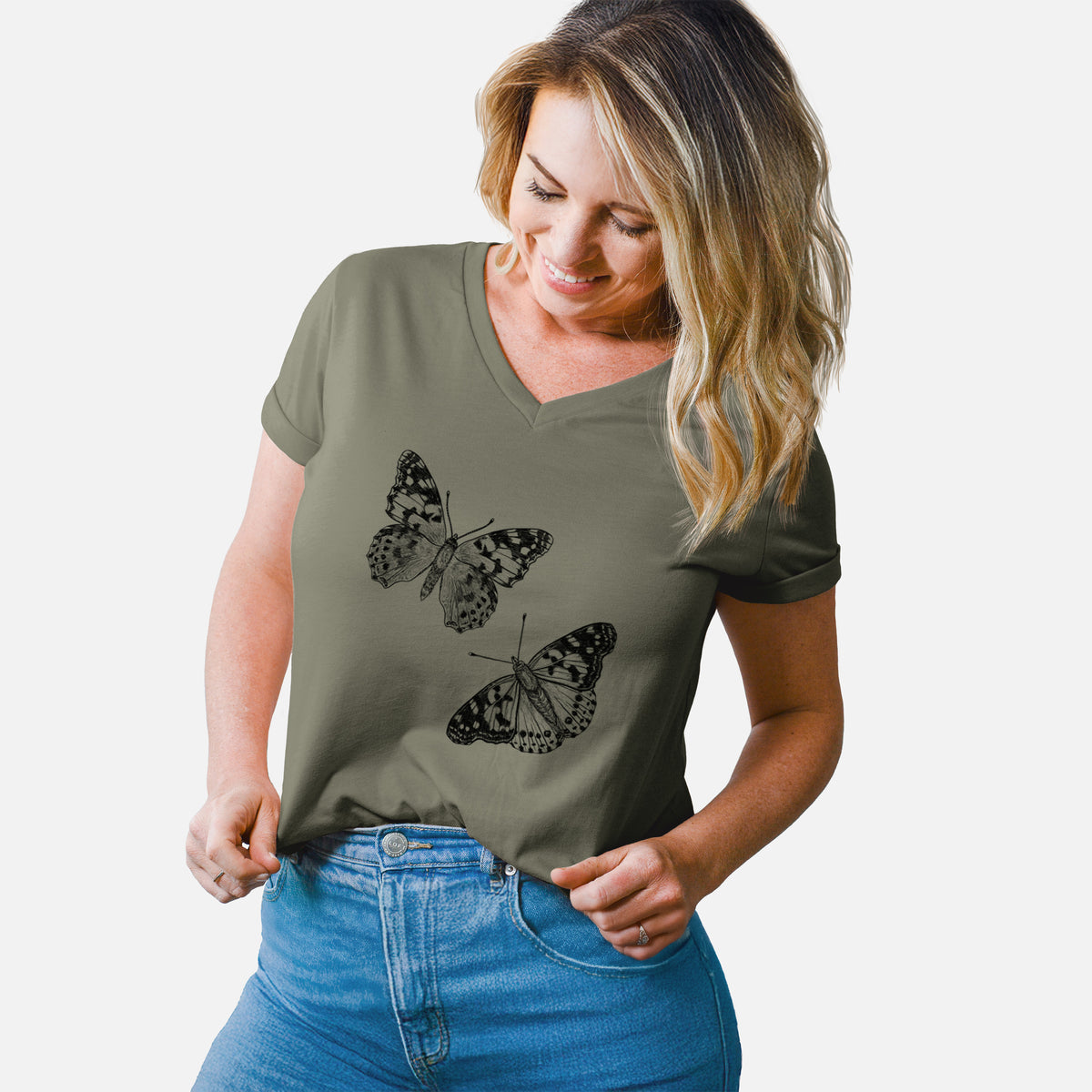 Woman wearing a military green women's relaxed fit cotton V-neck t-shirt printed with a detailed black ink illustration of two painted lady butterflies.