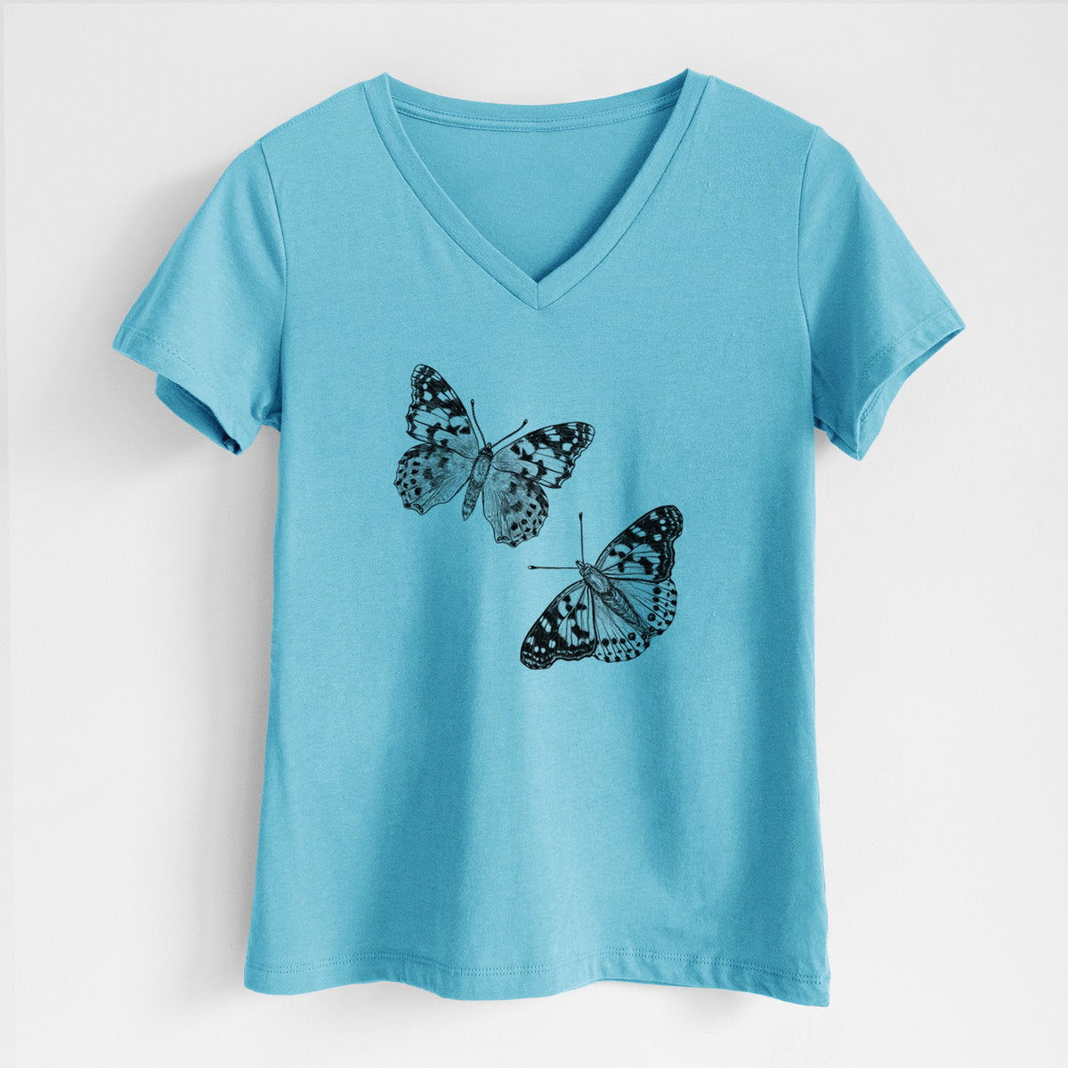 Turquoise women's relaxed fit cotton V-neck t-shirt laid flat, printed with a detailed black ink illustration of two painted lady butterflies.