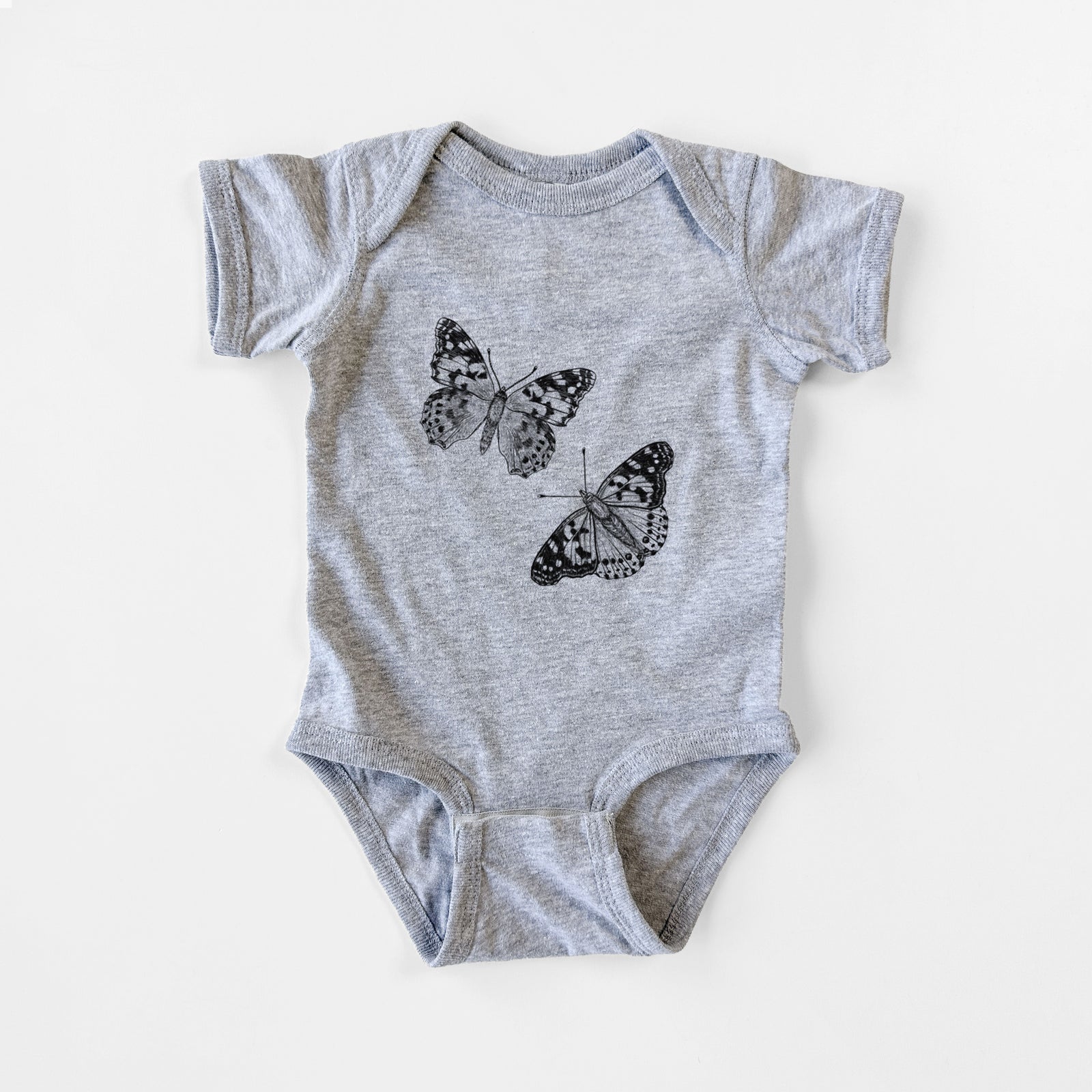 Grey baby bodysuit laid flat, printed with a detailed black ink illustration of two painted lady butterflies.