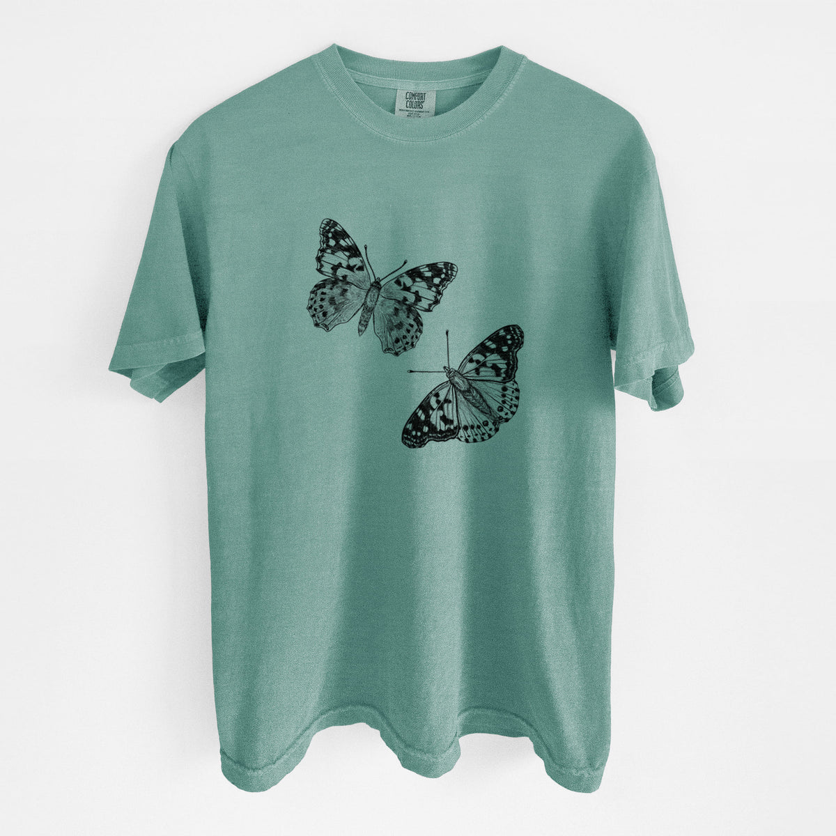 Reef green Comfort Colors t-shirt laid flat, printed with a detailed black ink illustration of two painted lady butterflies.