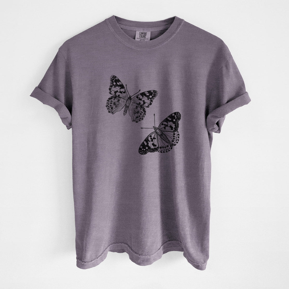 Wine red Comfort Colors t-shirt laid flat, printed with a detailed black ink illustration of two painted lady butterflies.