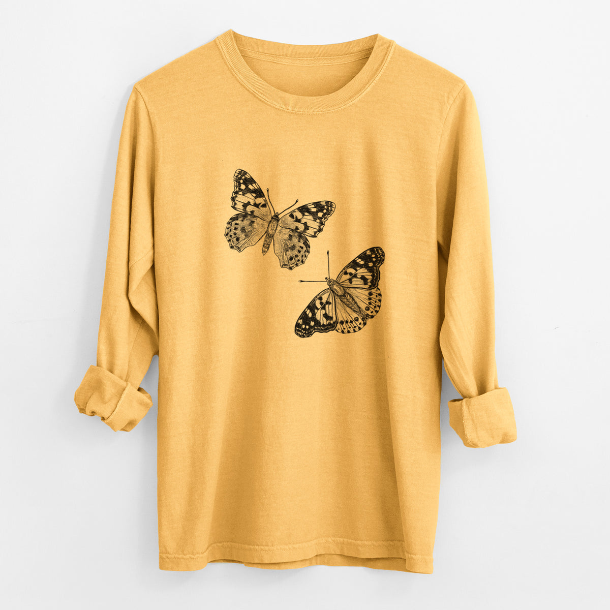 Golden wheat yellow Comfort Colors long sleeve shirt laid flat with the cuffs rolled, printed with a detailed black ink illustration of two painted lady butterflies.