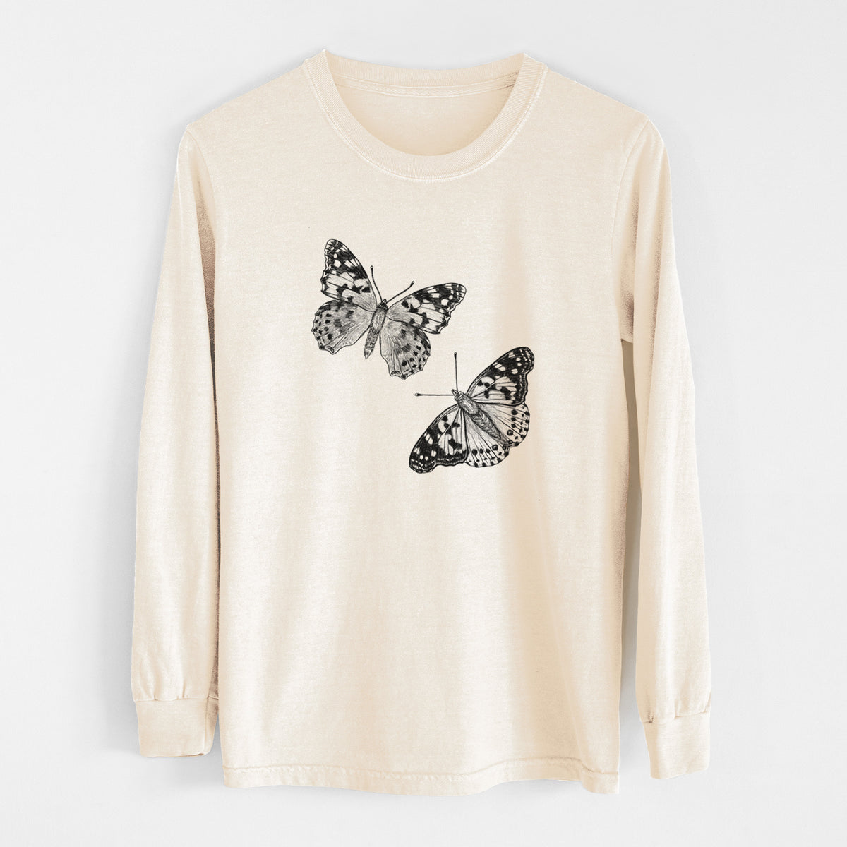 Ivory Comfort Colors long sleeve shirt laid flat, printed with a detailed black ink illustration of two painted lady butterflies.