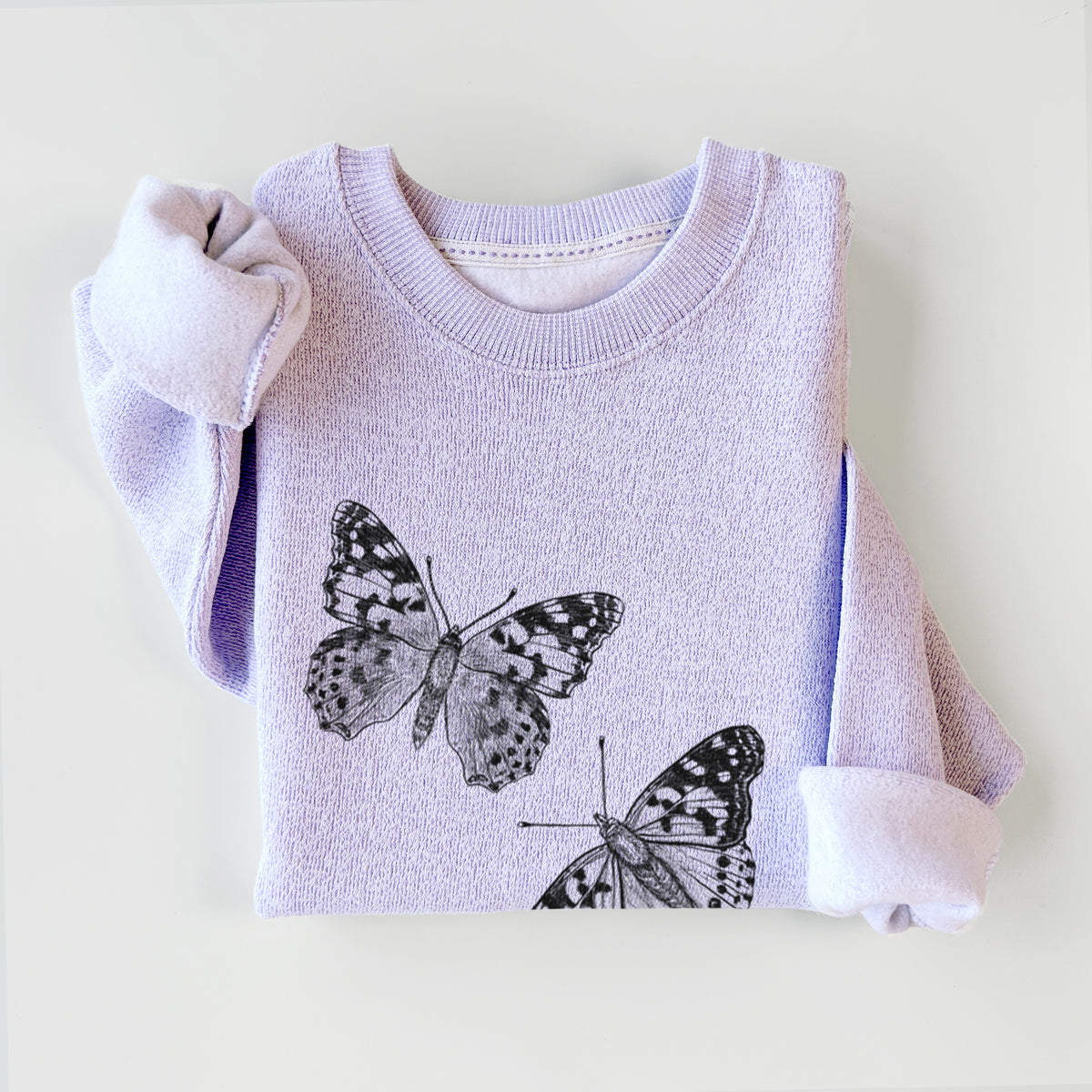 Ice purple knit sweatshirt printed with a detailed black ink illustration of two painted lady butterflies, styled flat.