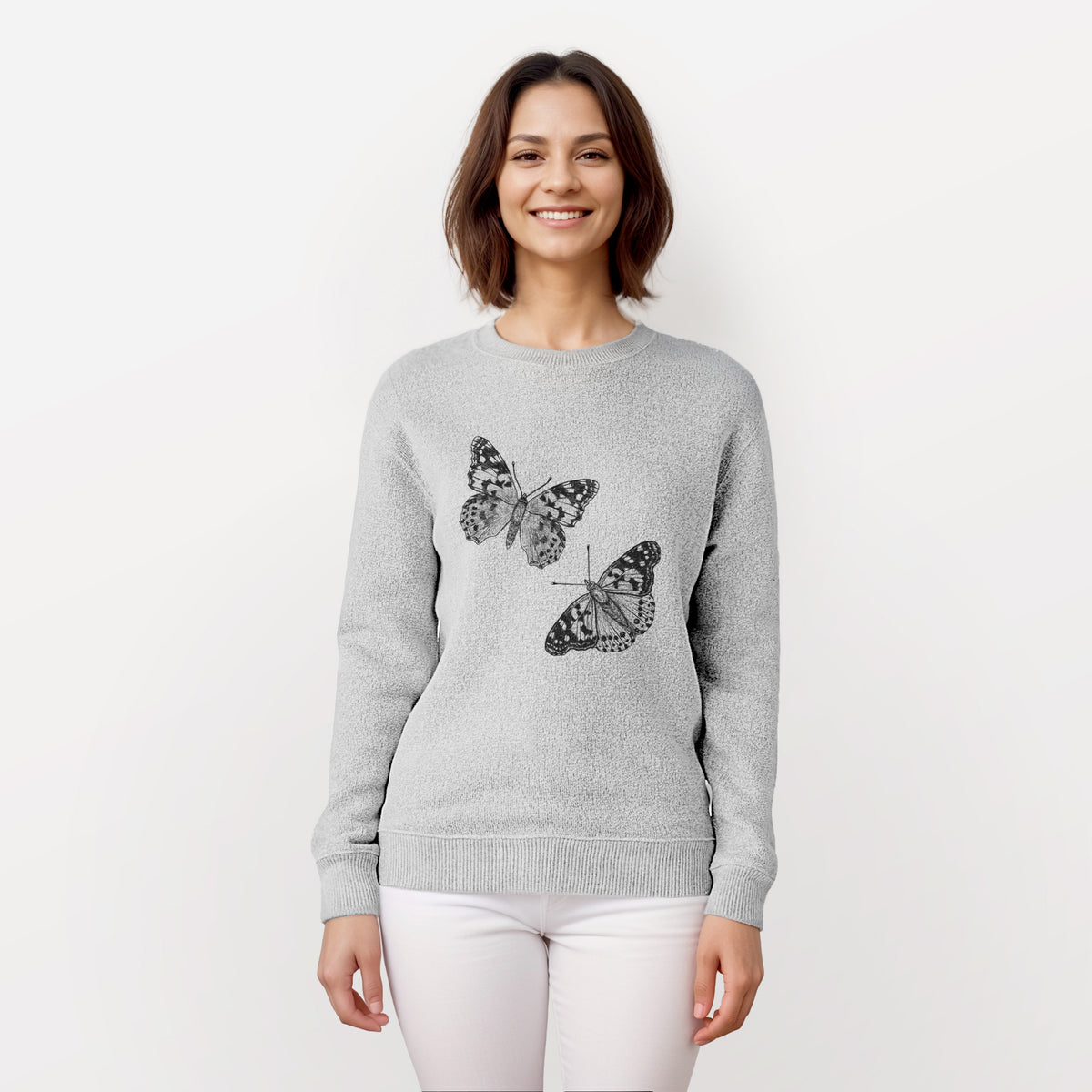 Woman wearing a knit sweatshirt printed with a detailed black ink illustration of two painted lady butterflies.