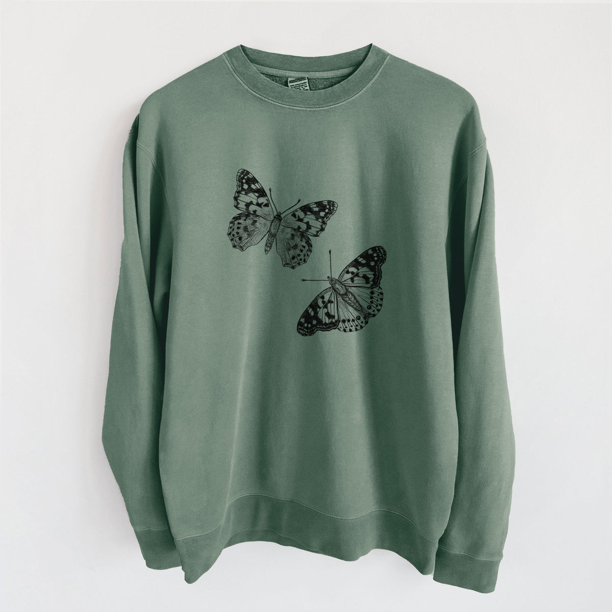Alpine green pigment dyed crewneck sweatshirt laid flat, printed with a detailed black ink illustration of two painted lady butterflies.