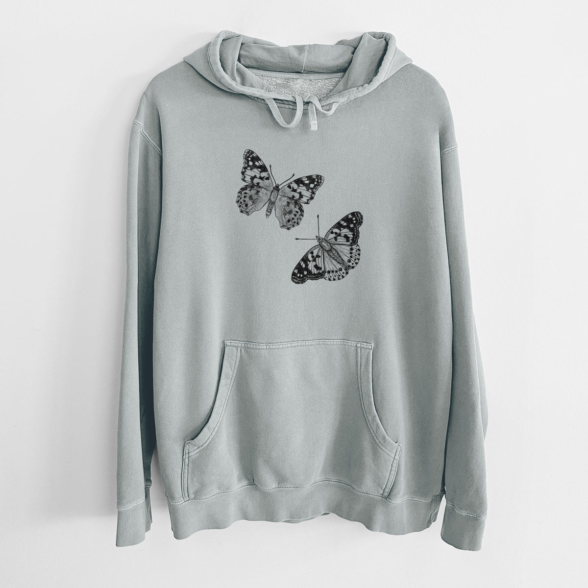 Sage green pigment dyed hoodie laid flat, printed with a detailed black ink illustration of two painted lady butterflies.