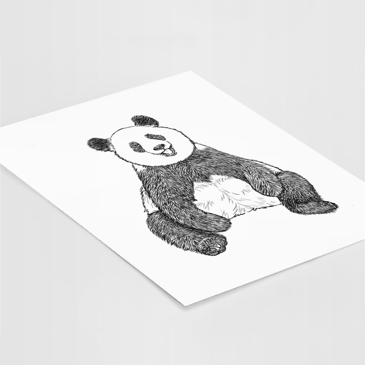 Art print of a black ink illustration of a giant panda sitting and facing forward, lying at an angle on a white surface.
