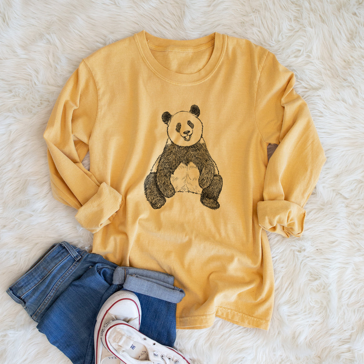 Golden wheat yellow Comfort Colors long sleeve shirt printed with a black ink illustration of a giant panda sitting and facing forward, shown in a lifestyle photo.