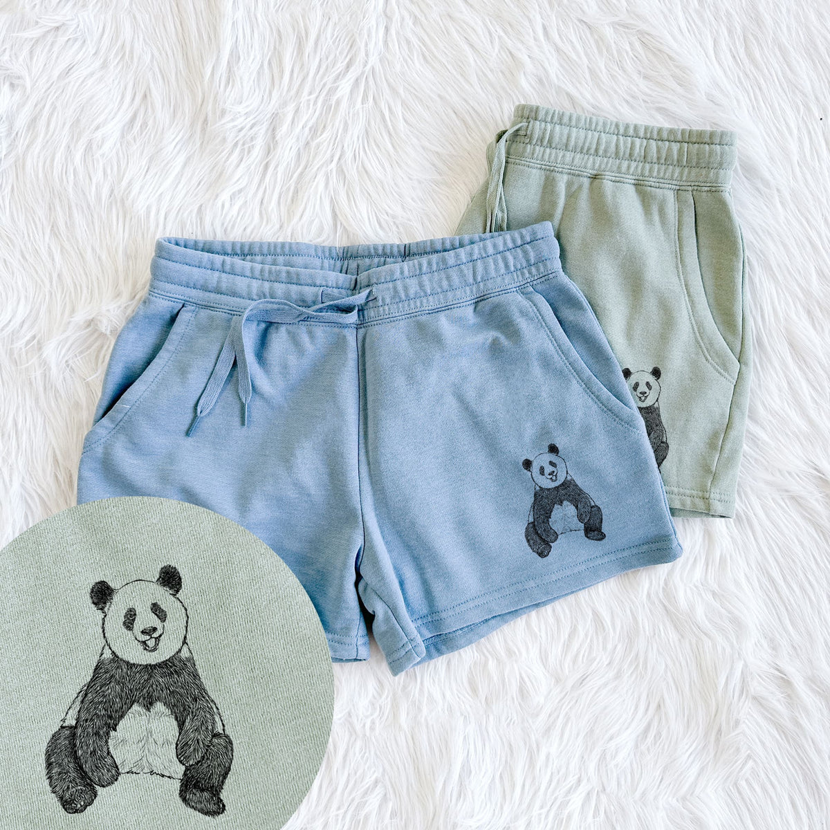 Two pairs of Cali Wave shorts in different colors printed with a black ink illustration of a giant panda sitting and facing forward, with a close-up of the print.