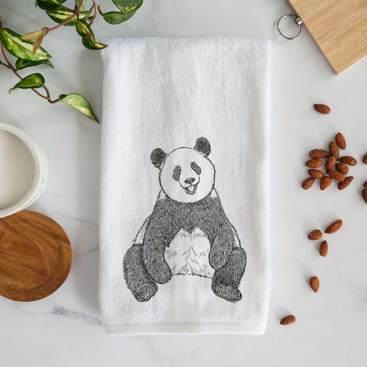 White hand towel printed with a black ink illustration of a giant panda sitting and facing forward.