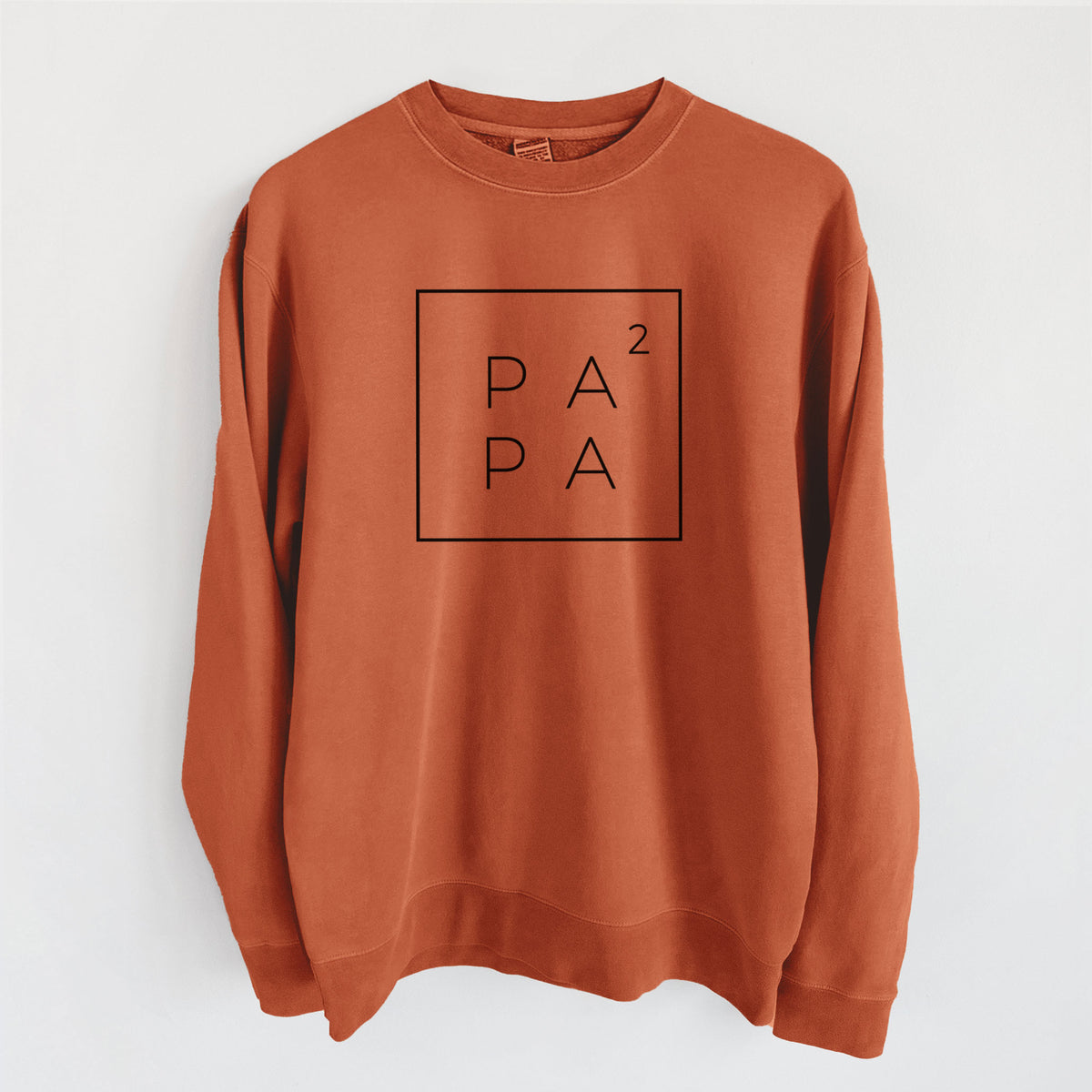 Amber orange pigment dyed crewneck sweatshirt laid flat, printed with the word PAPA stacked inside a square outline with a small squared symbol, for a papa of two.
