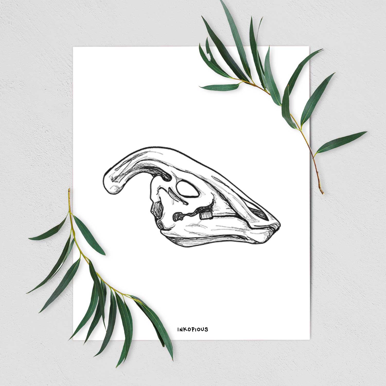 Art print of a detailed black ink illustration of a crested Parasaurolophus skull, shown with eucalyptus leaves.