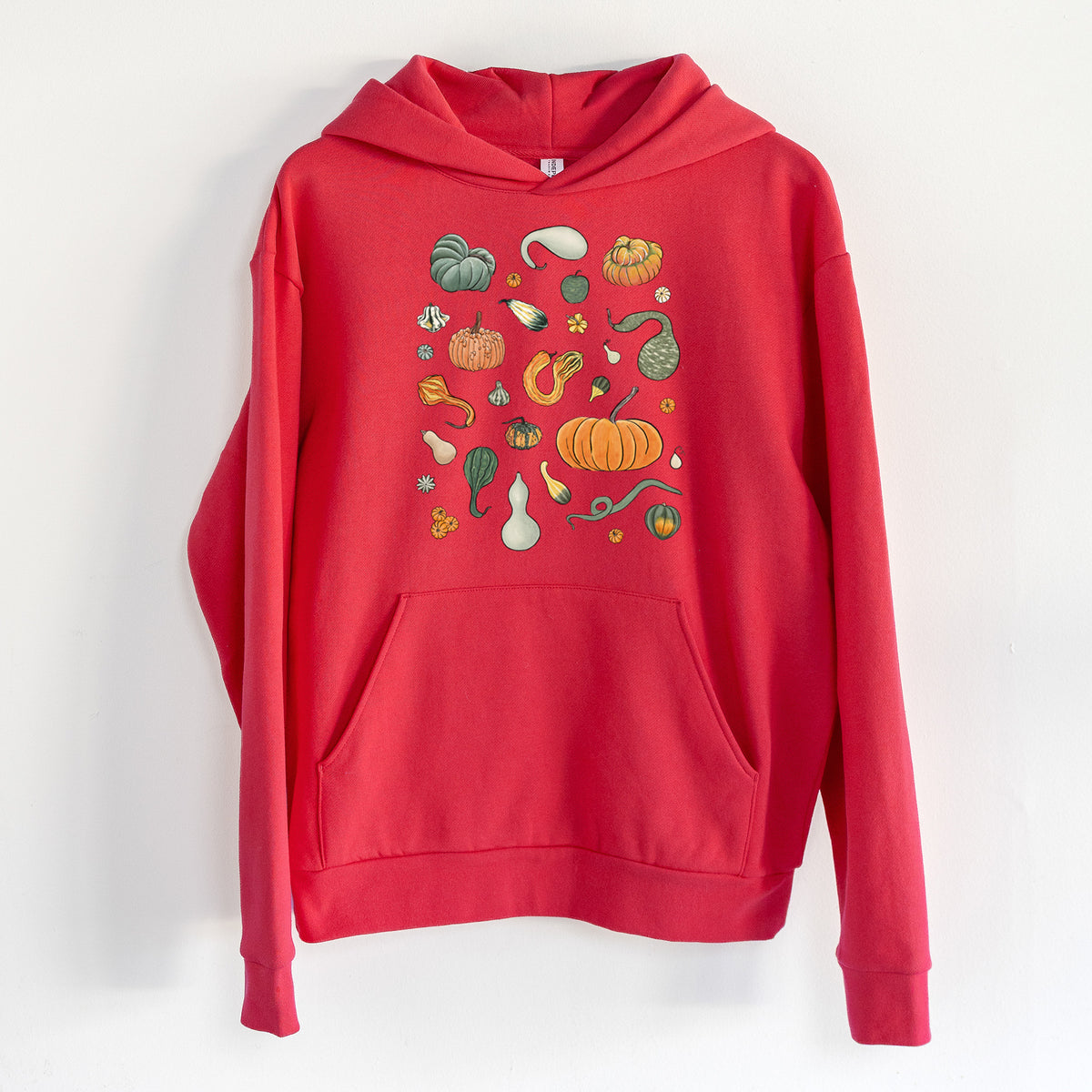 Pumpkin Patch Finds - Statement Midweight Hoodie in Cherry Red, hanging on a white wall, with a front kangaroo pocket and no drawcords.