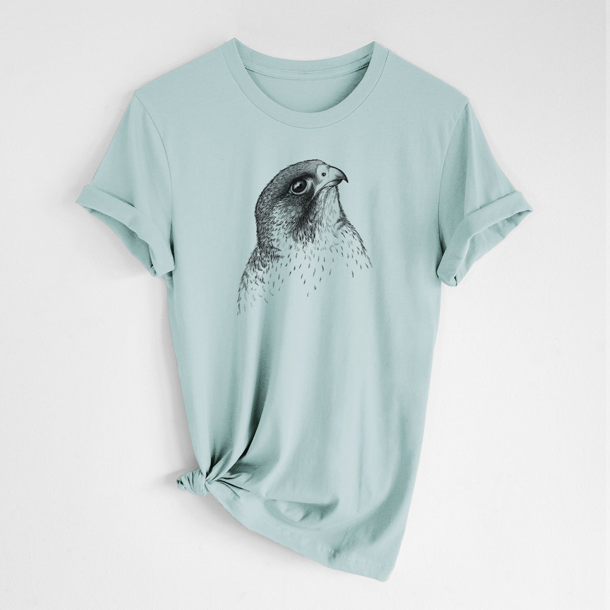Dusty blue lightweight cotton t-shirt laid flat with the sleeves rolled, printed with a detailed black ink portrait of a peregrine falcon's head.