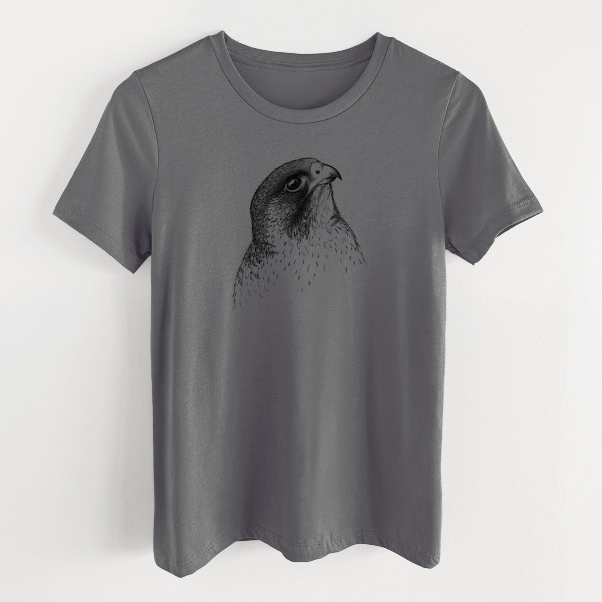 Asphalt women's relaxed fit cotton t-shirt laid flat, printed with a detailed black ink portrait of a peregrine falcon's head.