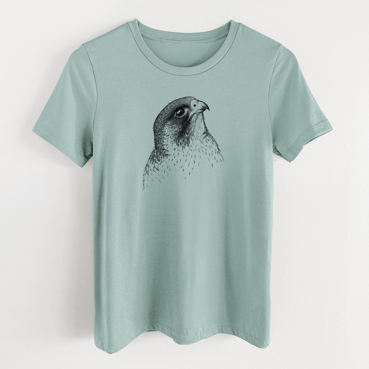 Dusty blue women's relaxed fit cotton t-shirt laid flat, printed with a detailed black ink portrait of a peregrine falcon's head.