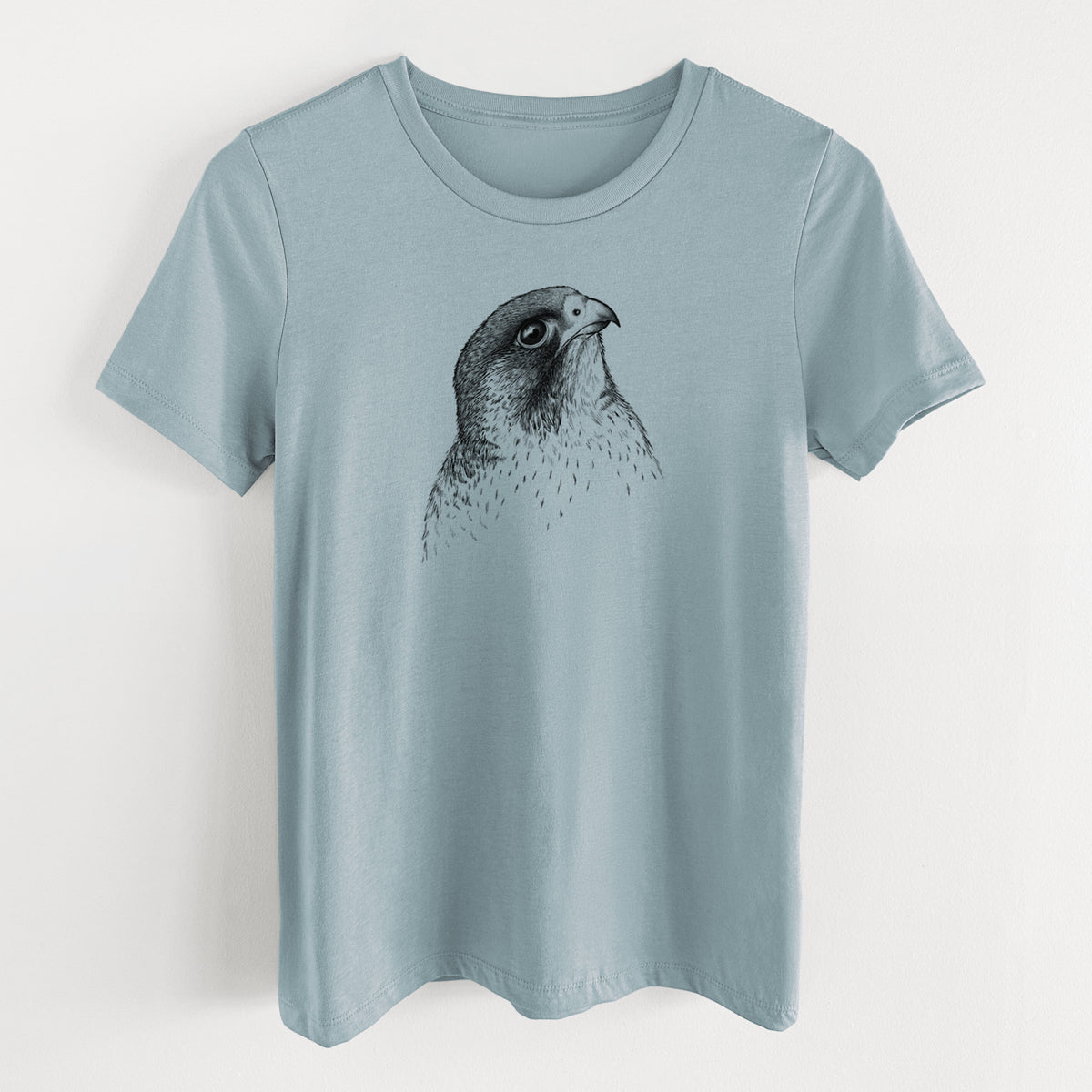 Vintage denim women's relaxed fit cotton t-shirt laid flat, printed with a detailed black ink portrait of a peregrine falcon's head.