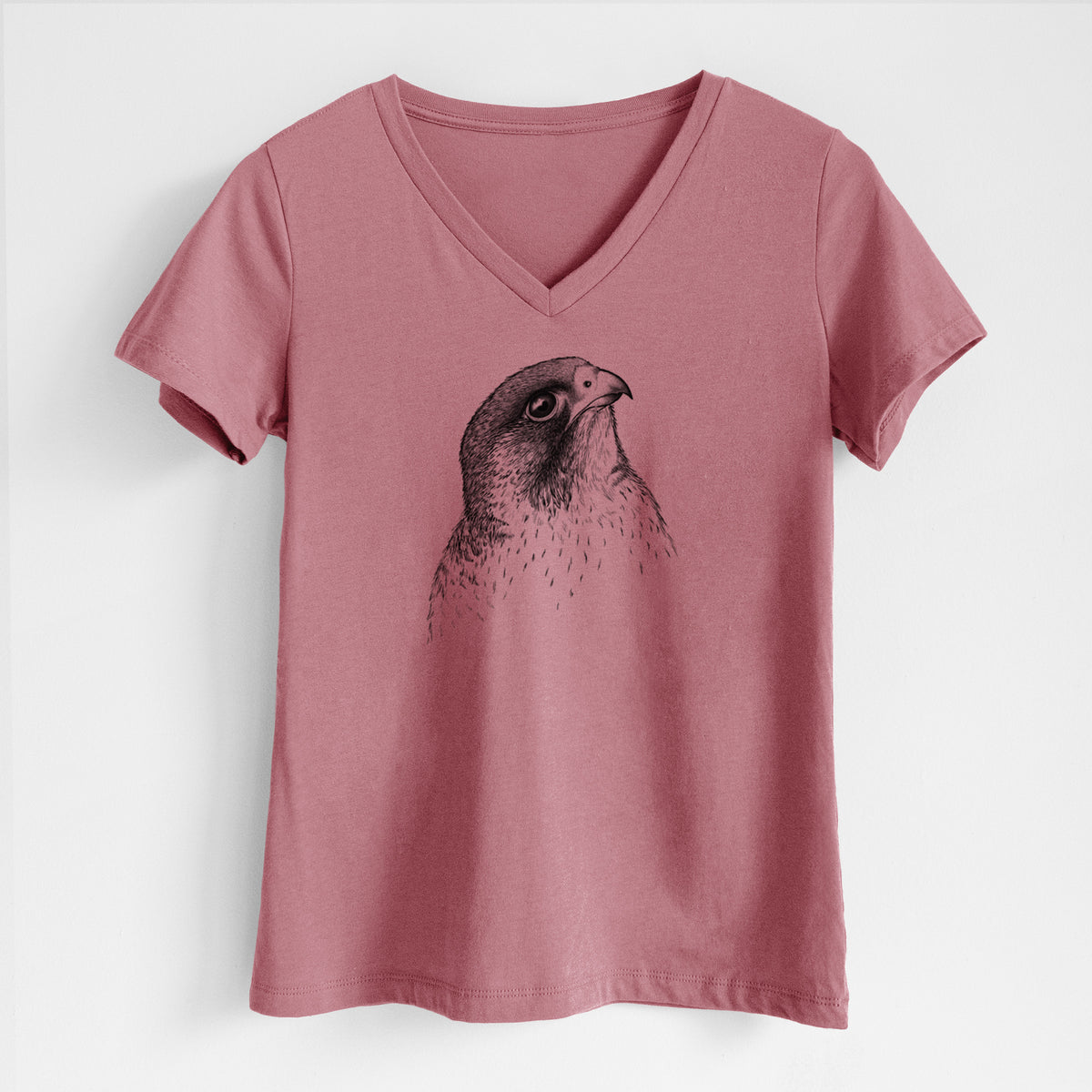 Mauve pink women's relaxed fit cotton V-neck t-shirt laid flat, printed with a detailed black ink portrait of a peregrine falcon's head.