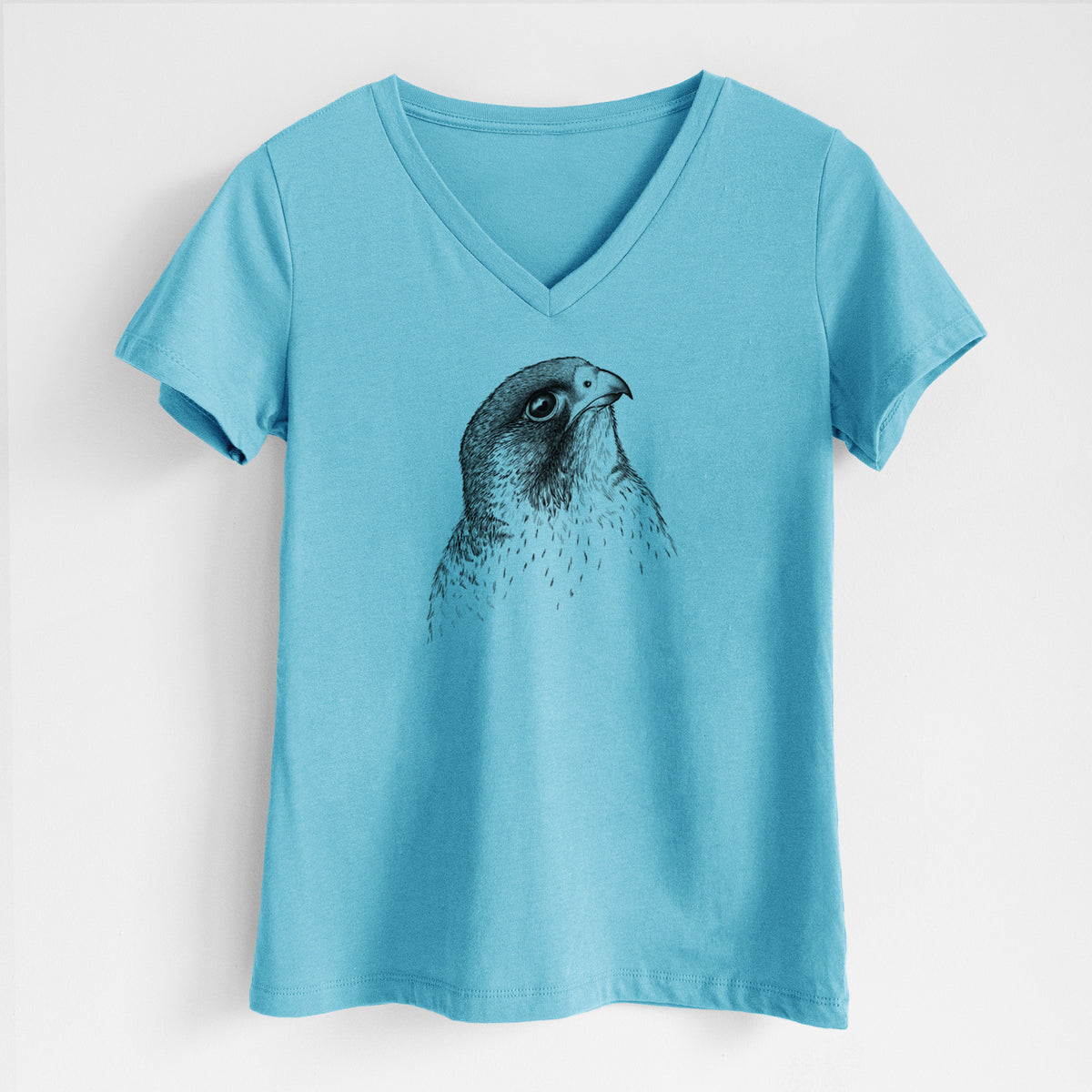 Turquoise women's relaxed fit cotton V-neck t-shirt laid flat, printed with a detailed black ink portrait of a peregrine falcon's head.