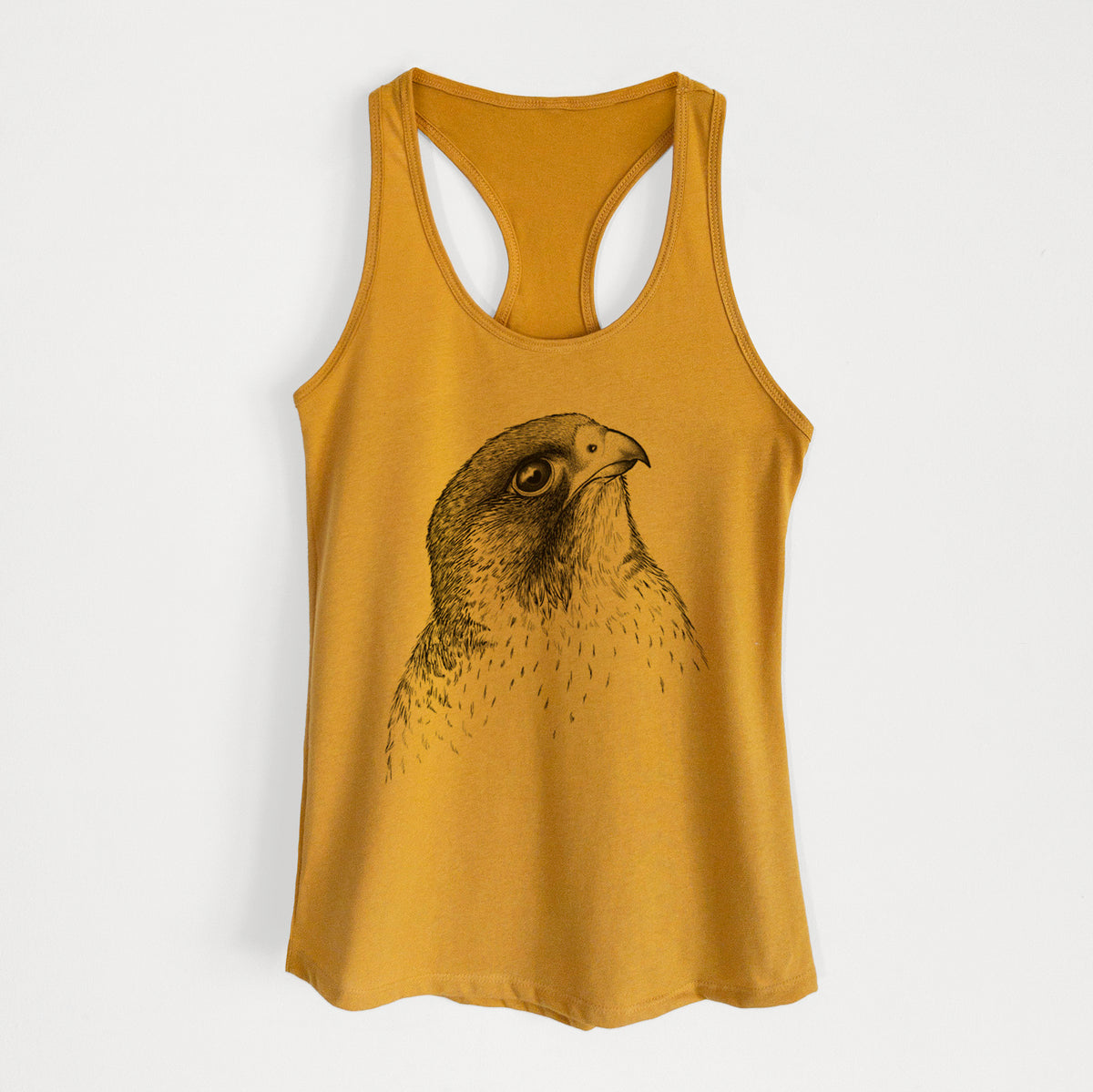 Gold women's racerback tank top laid flat, printed with a detailed black ink portrait of a peregrine falcon's head.