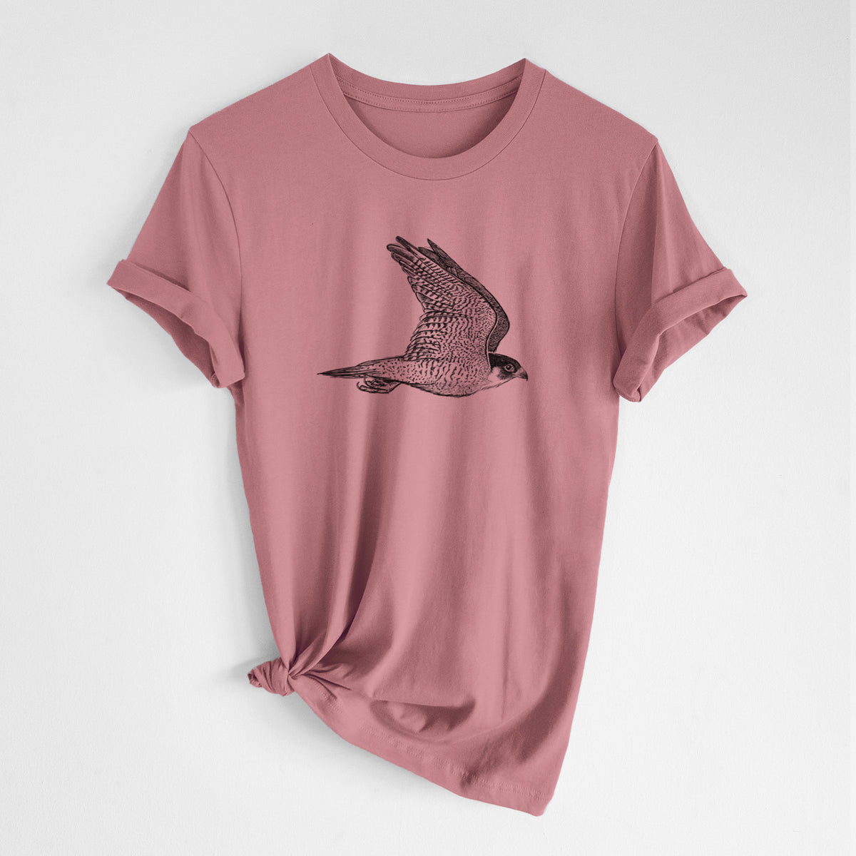 Mauve pink lightweight cotton t-shirt laid flat with the sleeves rolled, printed with a detailed black ink illustration of a peregrine falcon in flight.