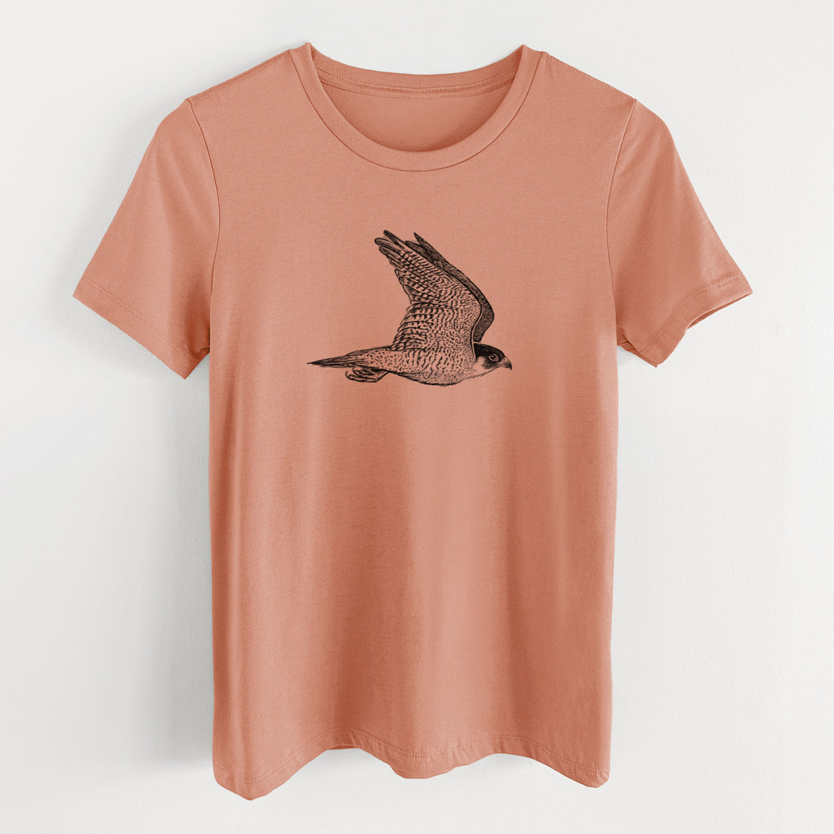 Terracotta orange women's relaxed fit cotton t-shirt laid flat, printed with a detailed black ink illustration of a peregrine falcon in flight.