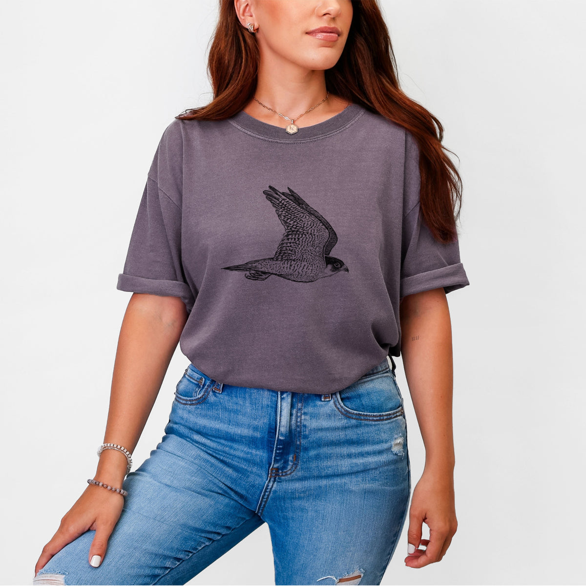 Woman wearing a Comfort Colors t-shirt printed with a detailed black ink illustration of a peregrine falcon in flight.