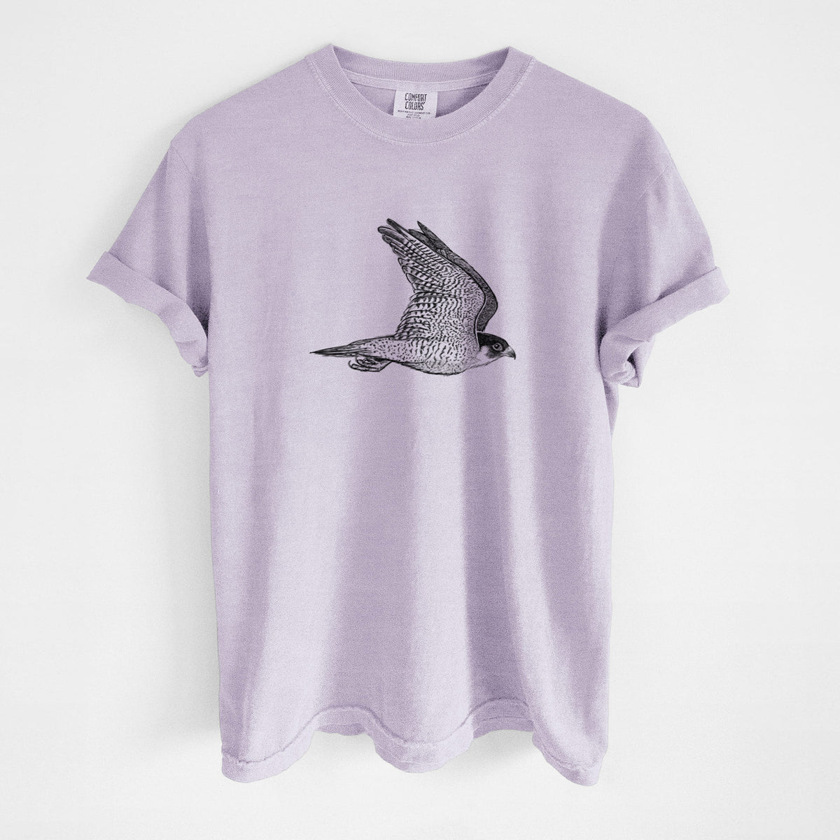 Orchid purple Comfort Colors t-shirt laid flat, printed with a detailed black ink illustration of a peregrine falcon in flight.