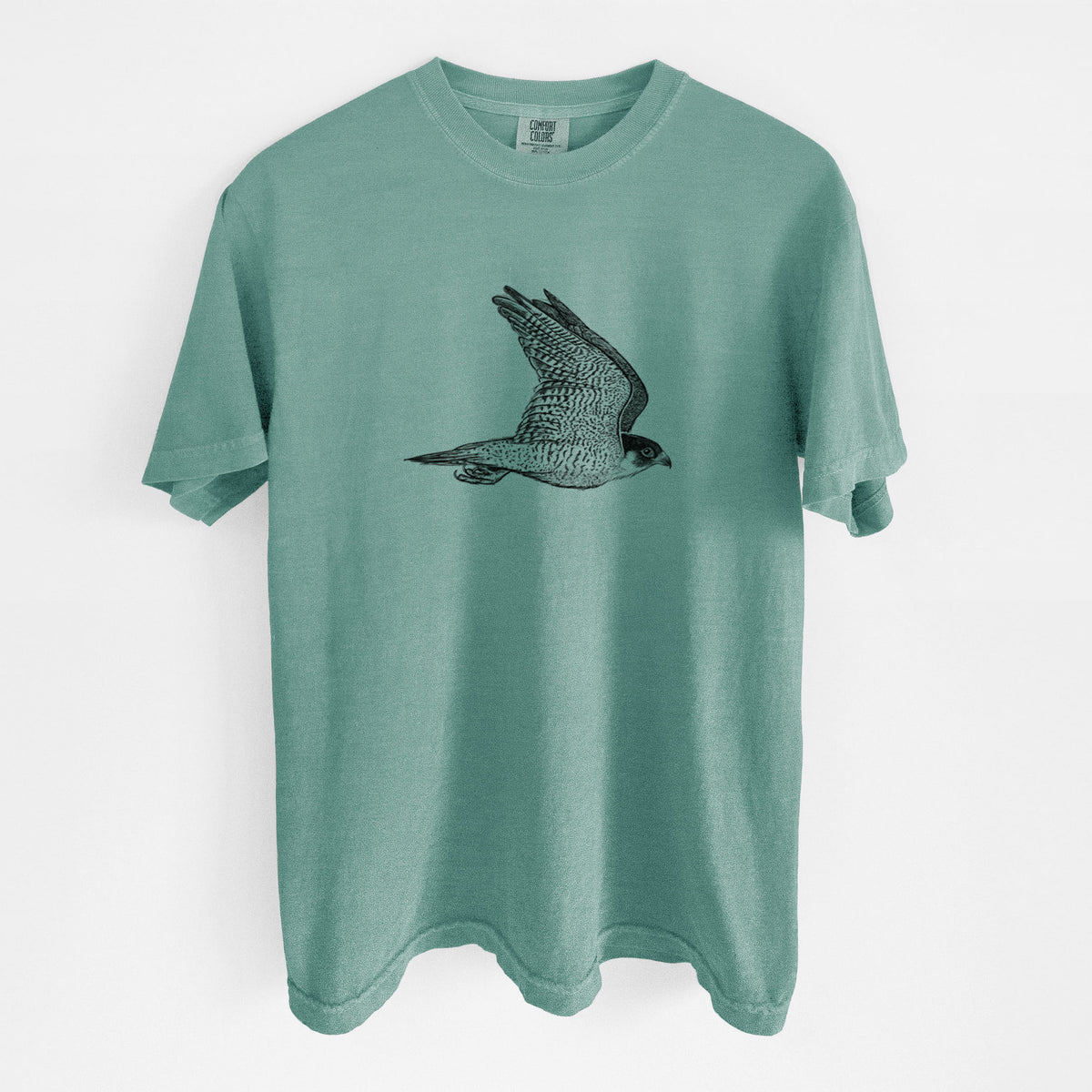 Reef green Comfort Colors t-shirt laid flat, printed with a detailed black ink illustration of a peregrine falcon in flight.