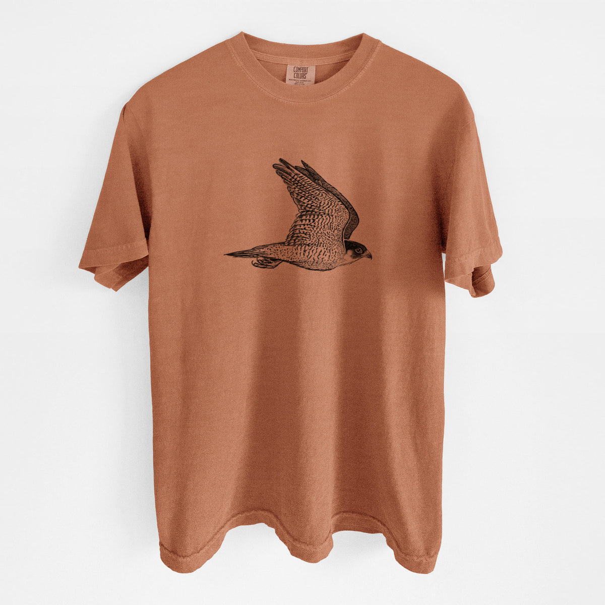 Yam burnt orange Comfort Colors t-shirt laid flat, printed with a detailed black ink illustration of a peregrine falcon in flight.