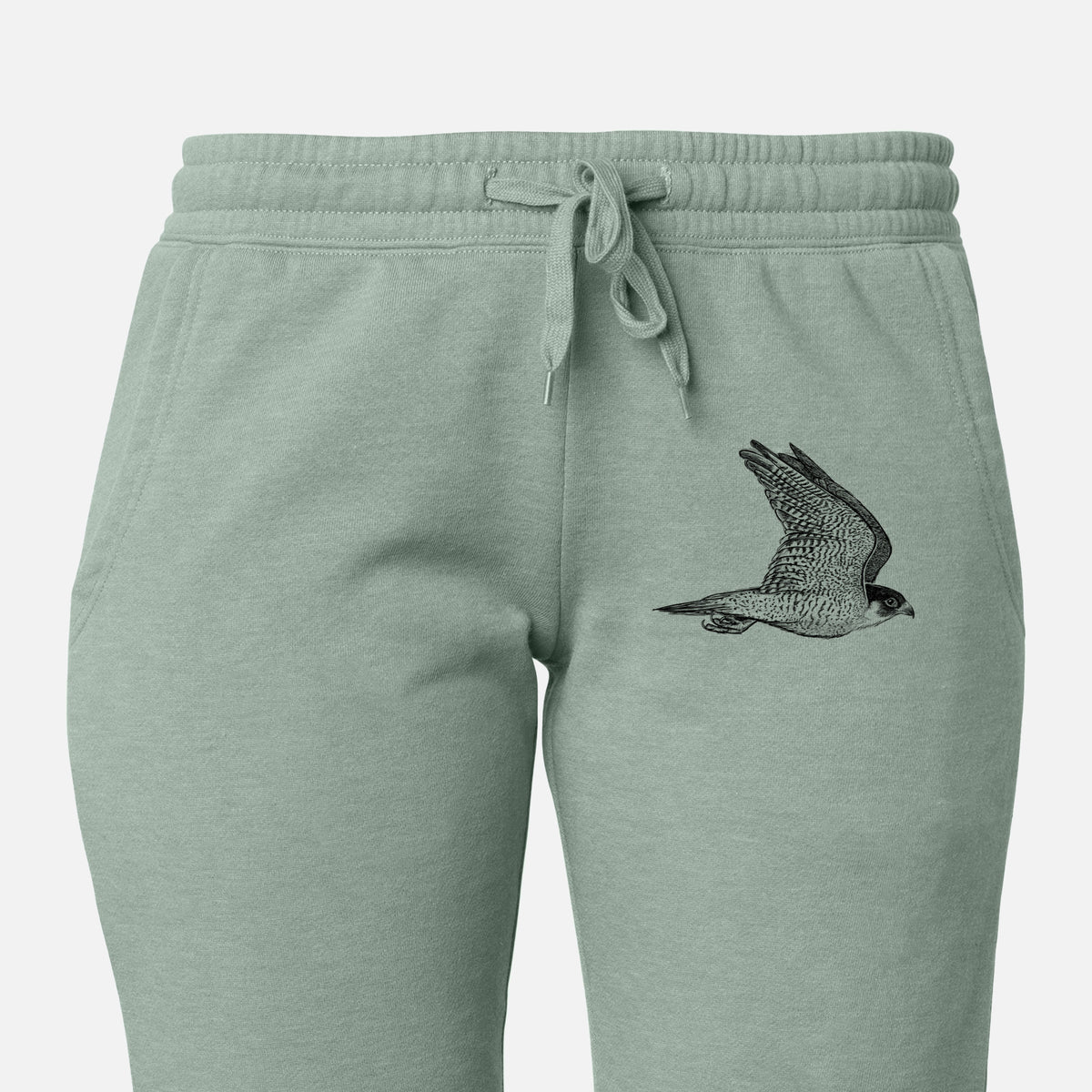 Front of sage green Cali Wave sweatpants, printed with a detailed black ink illustration of a peregrine falcon in flight on the leg.