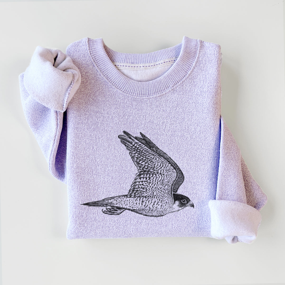 Ice purple knit sweatshirt printed with a detailed black ink illustration of a peregrine falcon in flight, styled flat.