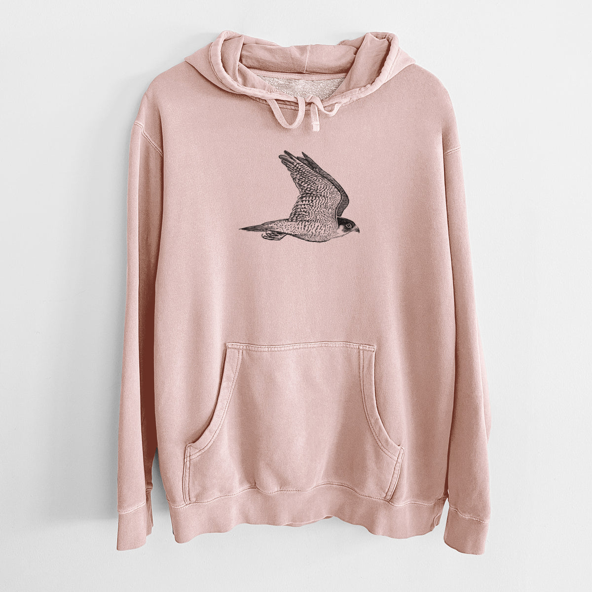 Dusty pink pigment dyed hoodie laid flat, printed with a detailed black ink illustration of a peregrine falcon in flight.