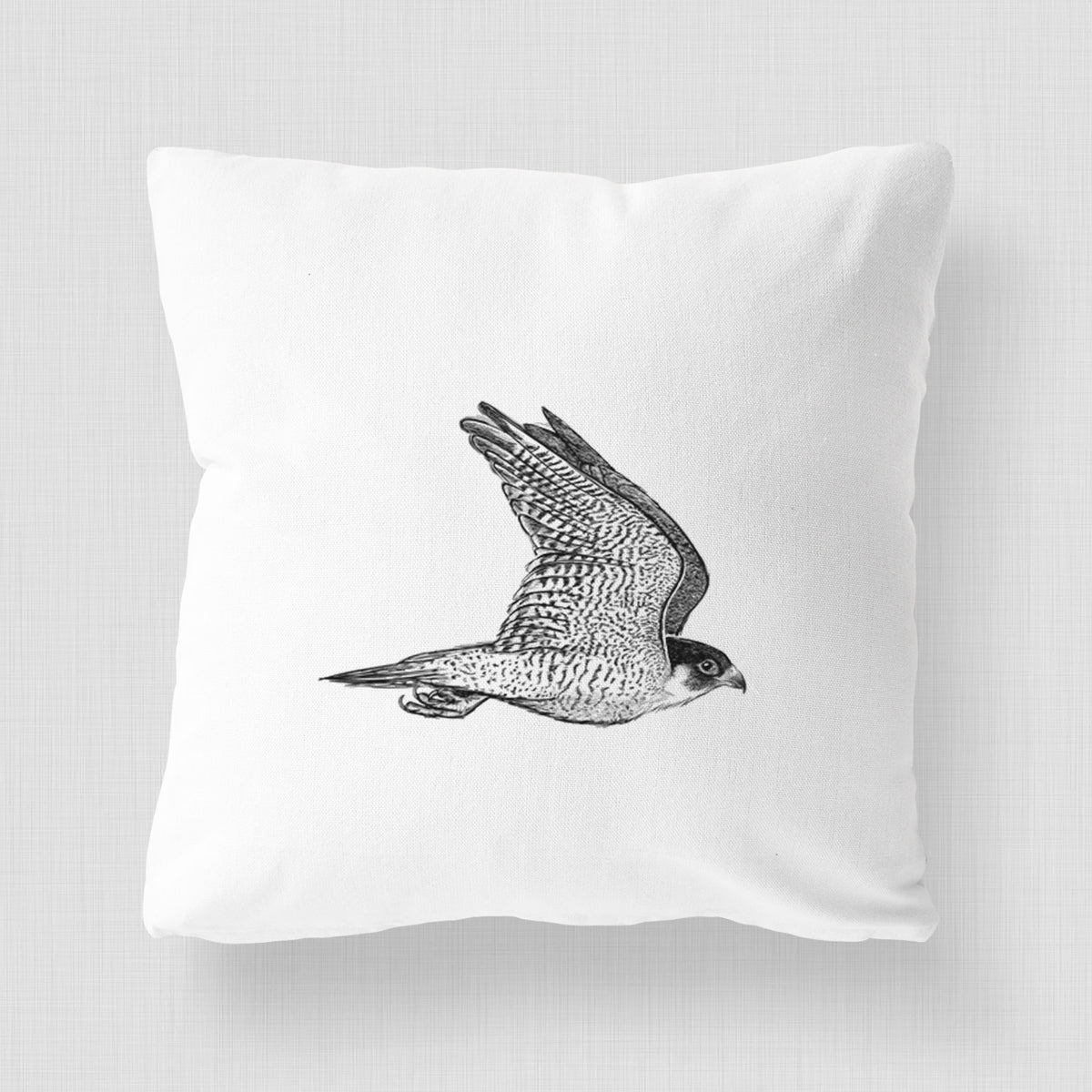 White pillow cover printed with a detailed black ink illustration of a peregrine falcon in flight.