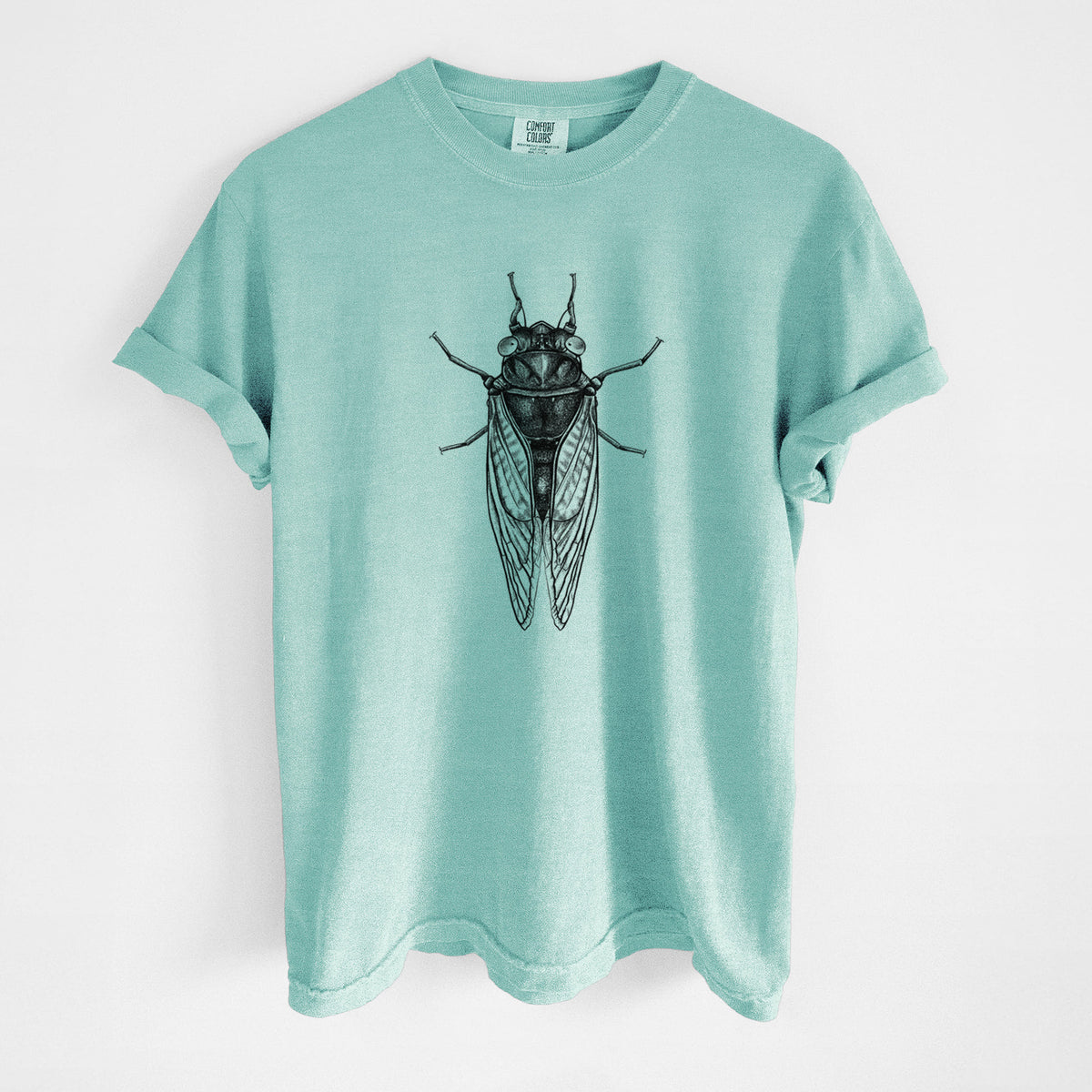 Chalky mint Comfort Colors t-shirt laid flat, printed with a detailed black ink illustration of a periodical cicada with its wings folded, seen from above.
