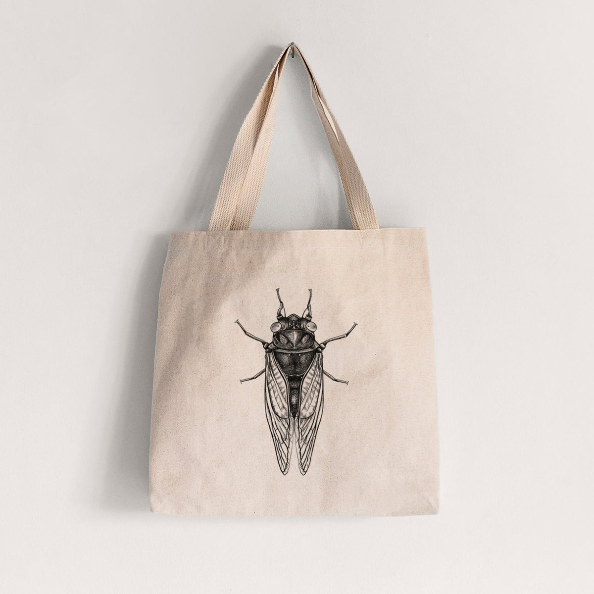 Natural canvas tote bag printed with a detailed black ink illustration of a periodical cicada with its wings folded, seen from above.
