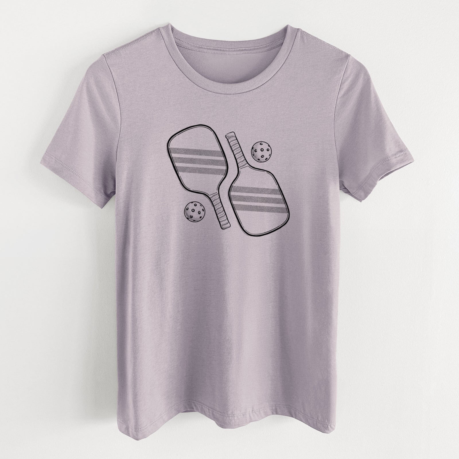 Light violet women's relaxed fit cotton t-shirt laid flat, printed with a black ink illustration of two crossed pickleball paddles with two pickleballs.