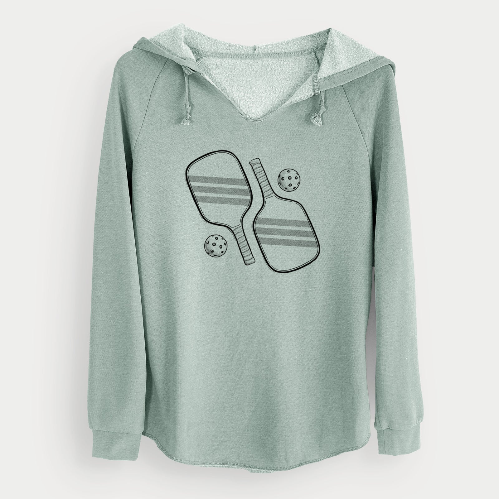 Sage green women's Cali Wave hooded sweatshirt laid flat, printed with a black ink illustration of two crossed pickleball paddles with two pickleballs.