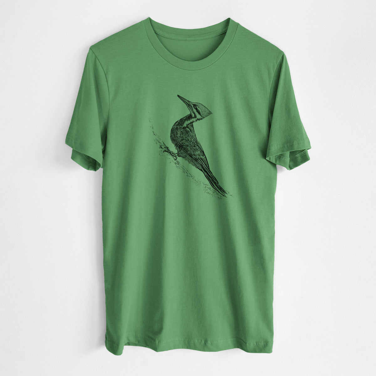 Leaf green lightweight cotton t-shirt laid flat, printed with a black ink illustration of a pileated woodpecker clinging to a tree trunk.