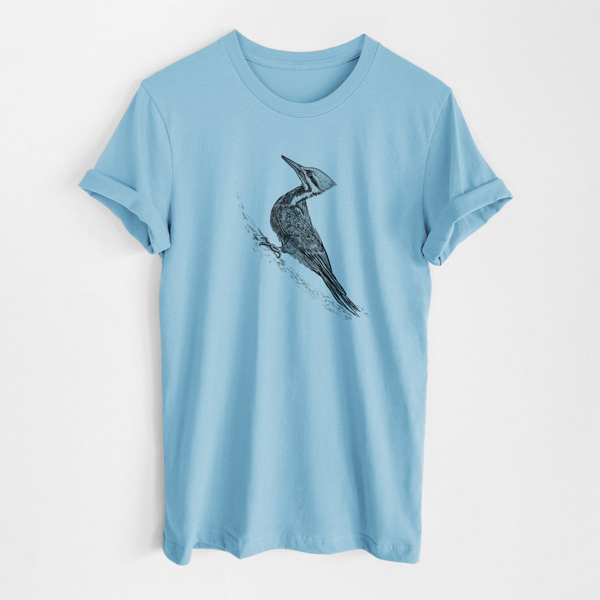 Ocean blue lightweight cotton t-shirt laid flat, printed with a black ink illustration of a pileated woodpecker clinging to a tree trunk.