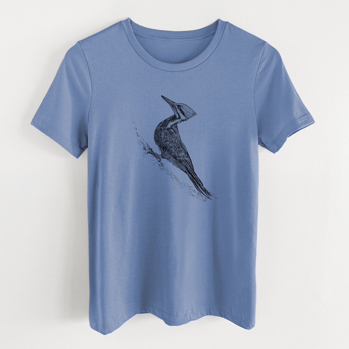 Blue bell women's relaxed fit cotton t-shirt laid flat, printed with a black ink illustration of a pileated woodpecker clinging to a tree trunk.